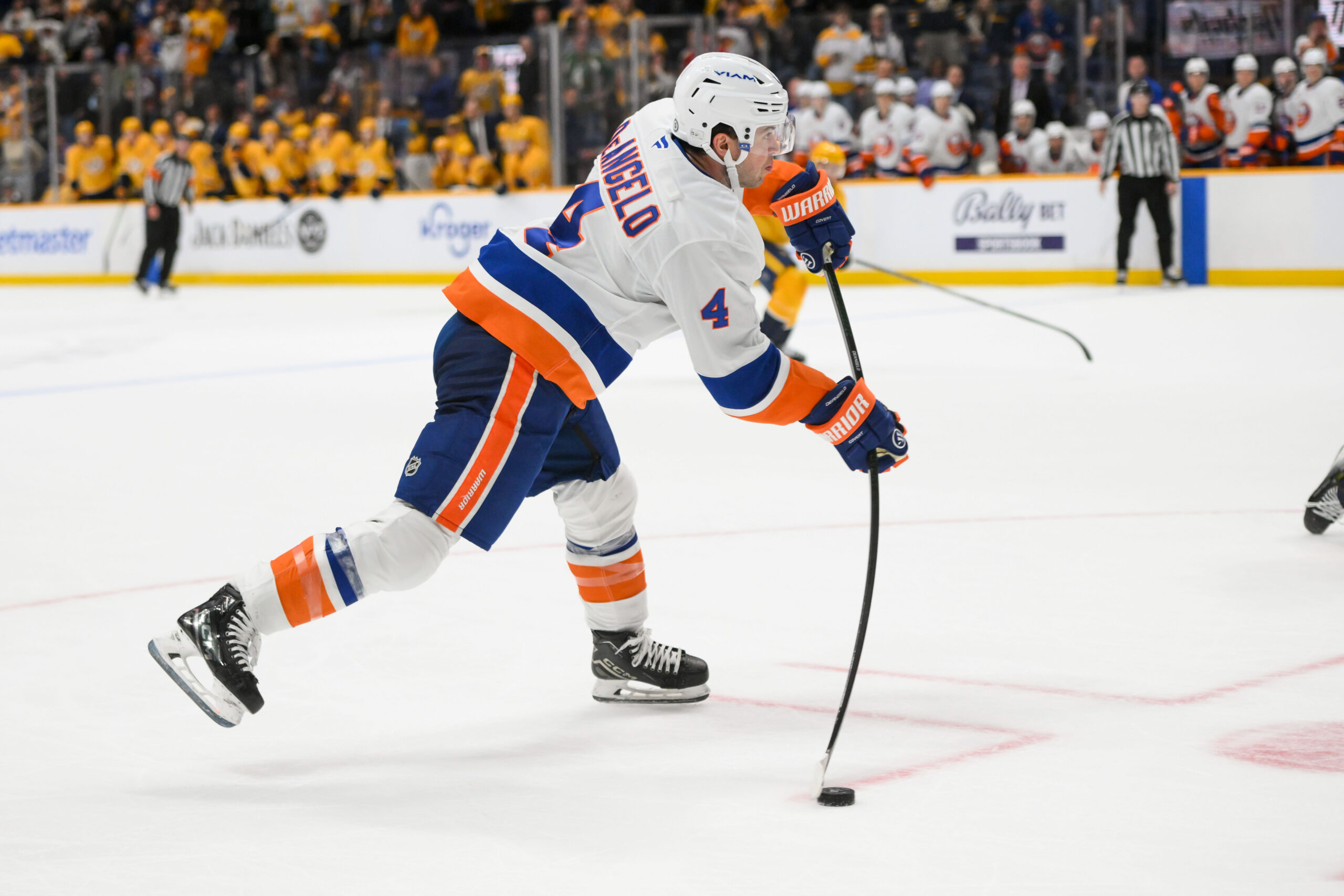 Apr 8, 2025; Nashville, Tennessee, USA;  New York Islanders defenseman Tony DeAngelo (4) takes a shot on goal against the Nashville Predators during the over time period at Bridgestone Arena. Mandatory Credit: Steve Roberts-Imagn Images