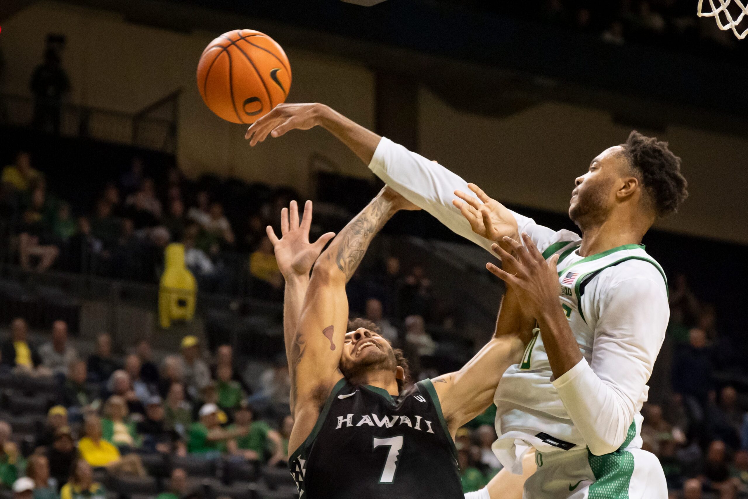 Oregon forward Kwame Evans Jr., right, fouls Hawaii guard Isaiah Kerr on a block as the Oregon Ducks host the Hawaii Rainbow Warriors on Nov. 4, 2025, at Matthew Knight Arena in Eugene, Oregon.
