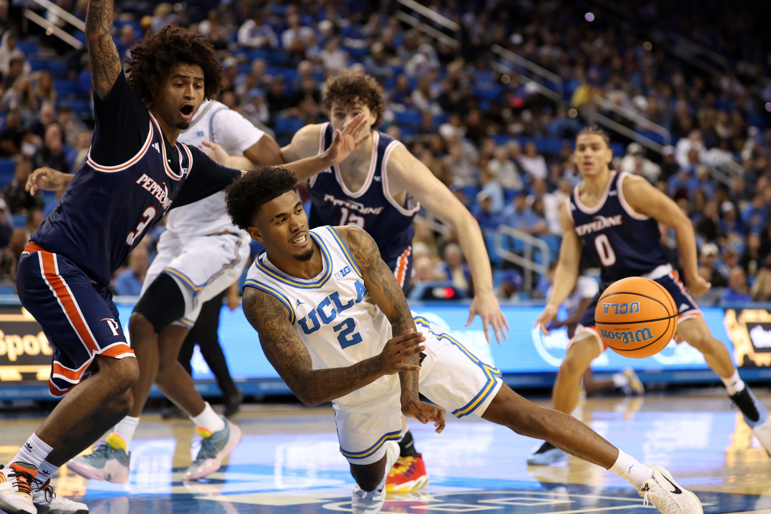 Nov 7, 2025; Los Angeles, California, USA;  UCLA Bruins guard Donovan Dent (2) passes the ball during the first half against the Pepperdine Waves at Pauley Pavilion presented by Wescom Financial. Mandatory Credit: Kiyoshi Mio-Imagn Images