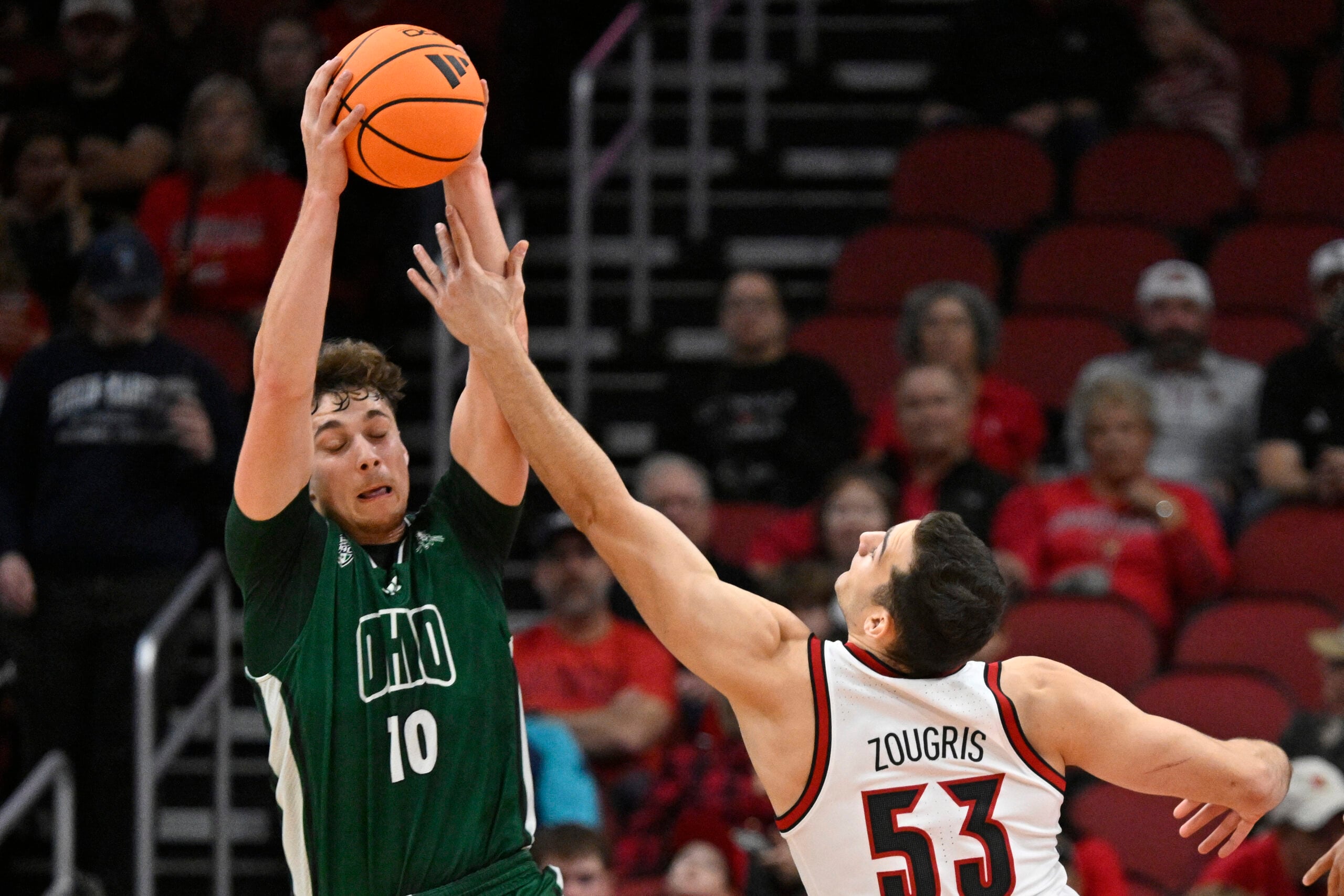 Nov 15, 2025; Louisville, Kentucky, USA;  Ohio Bobcats forward Aidan Hadaway (10) battles Louisville Cardinals forward Vangelis Zougris (53) for a rebound during the first half at KFC Yum! Center. Mandatory Credit: Jamie Rhodes-Imagn Images