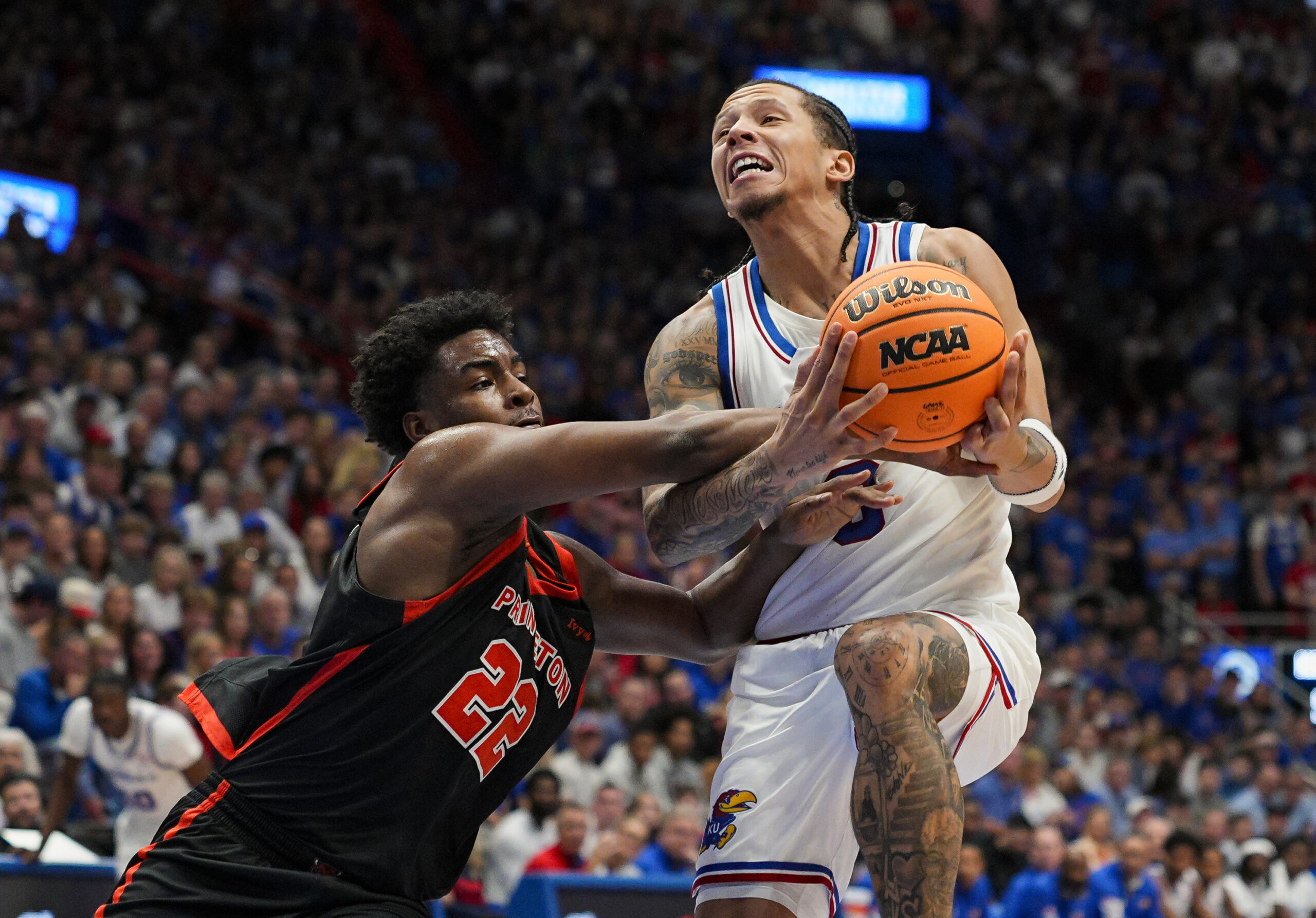 Nov 15, 2025; Lawrence, Kansas, USA; Kansas Jayhawks guard Tre White (3) is fouled while shooting against Princeton Tigers guard Dalen Davis (22) during the first half at Allen Fieldhouse. Mandatory Credit: Jay Biggerstaff-Imagn Images