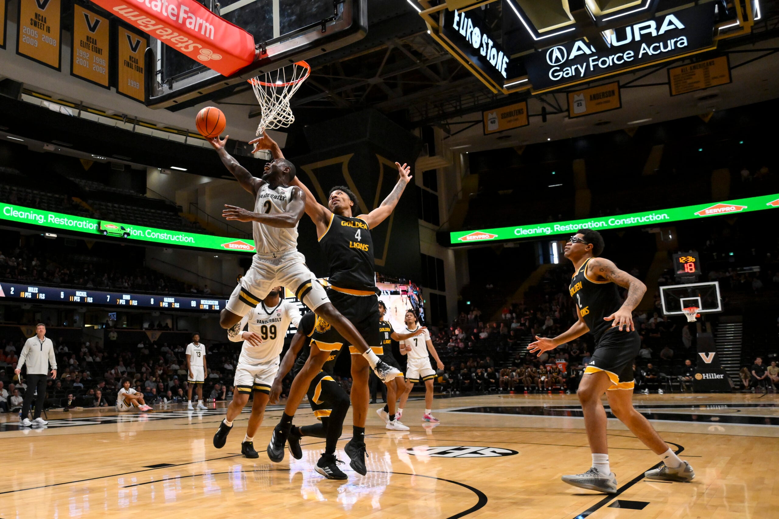 Nov 15, 2025; Nashville, Tennessee, USA;  Vanderbilt Commodores guard Duke Miles (2) goes under the arms of Arkansas-Pine Bluff Golden Lions forward Jaquan Scott (4) during the second half at Memorial Gymnasium. Mandatory Credit: Steve Roberts-Imagn Images