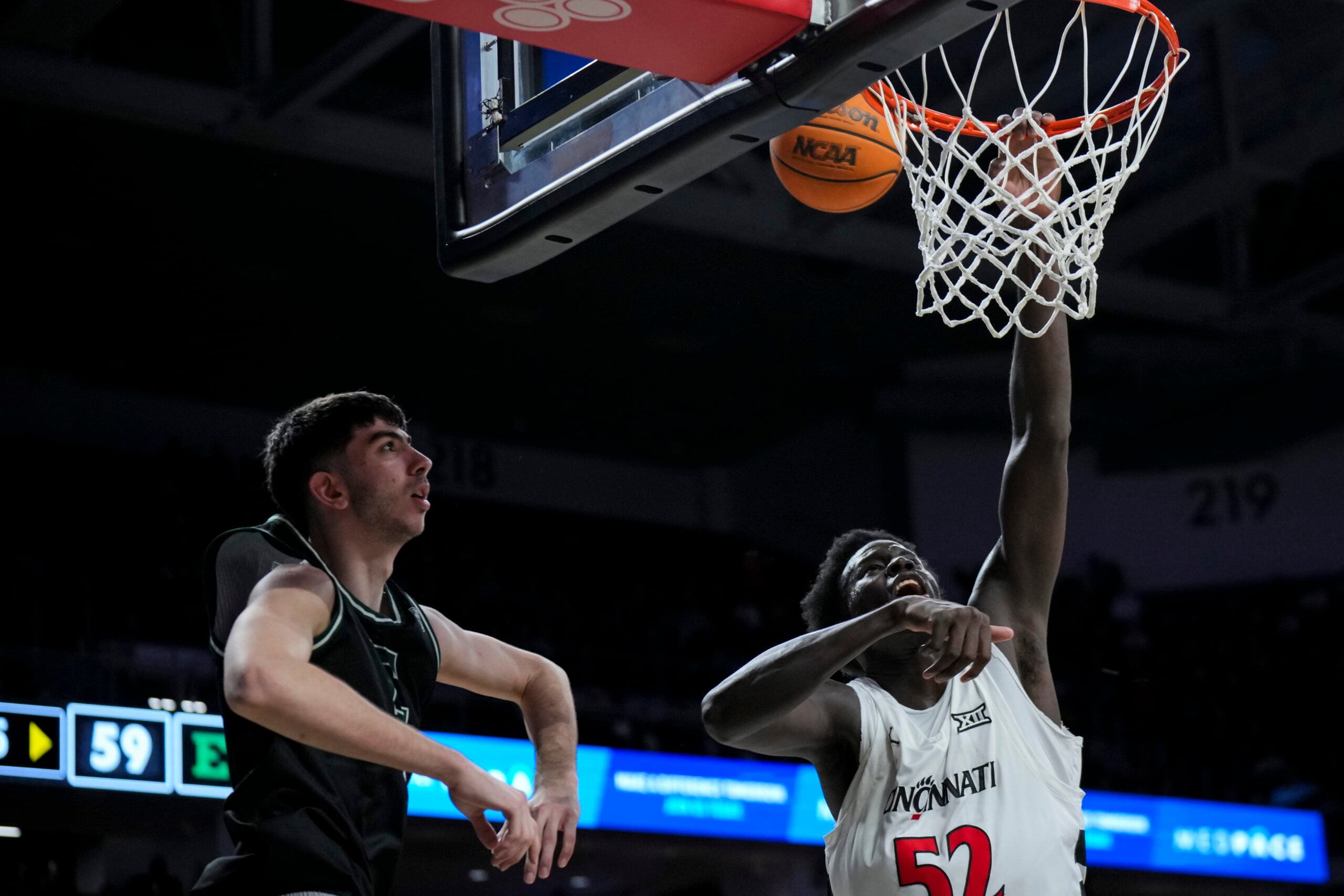 Nov 26, 2025; Cincinnati, Ohio, USA;  Cincinnati Bearcats center Moustapha Thiam (52) misses a dunk against Eastern Michigan Eagles forward Mohammad Habhab (4) in the second half at Fifth Third Arena. Mandatory Credit: Aaron Doster-Imagn Images