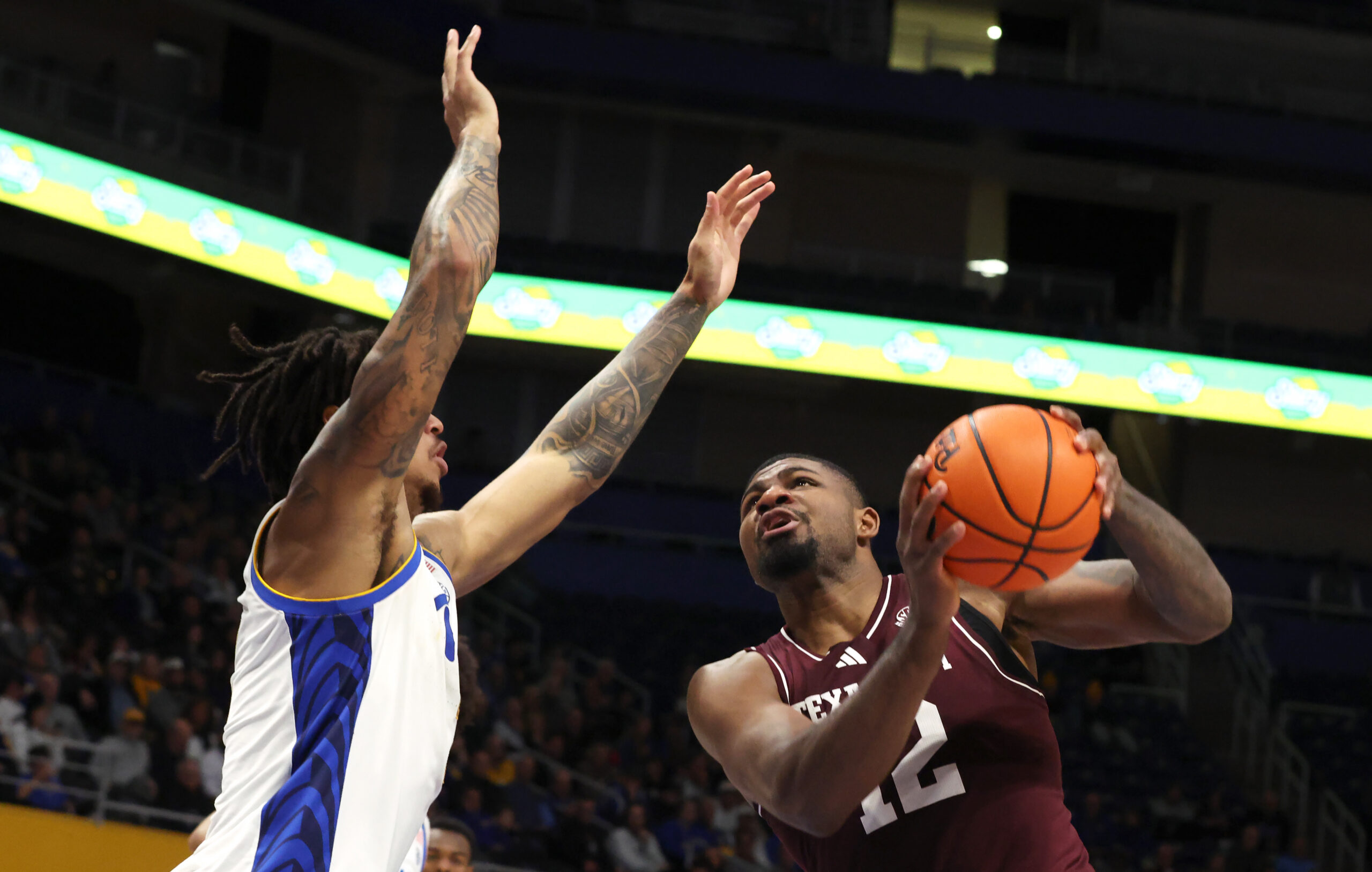 Dec 2, 2025; Pittsburgh, Pennsylvania, USA;  Texas A&M Aggies forward Rashaun Agee (12) shoots against Pittsburgh Panthers forward Cameron Corhen (left) during the second half at the Petersen Events Center. Mandatory Credit: Charles LeClaire-Imagn Images
