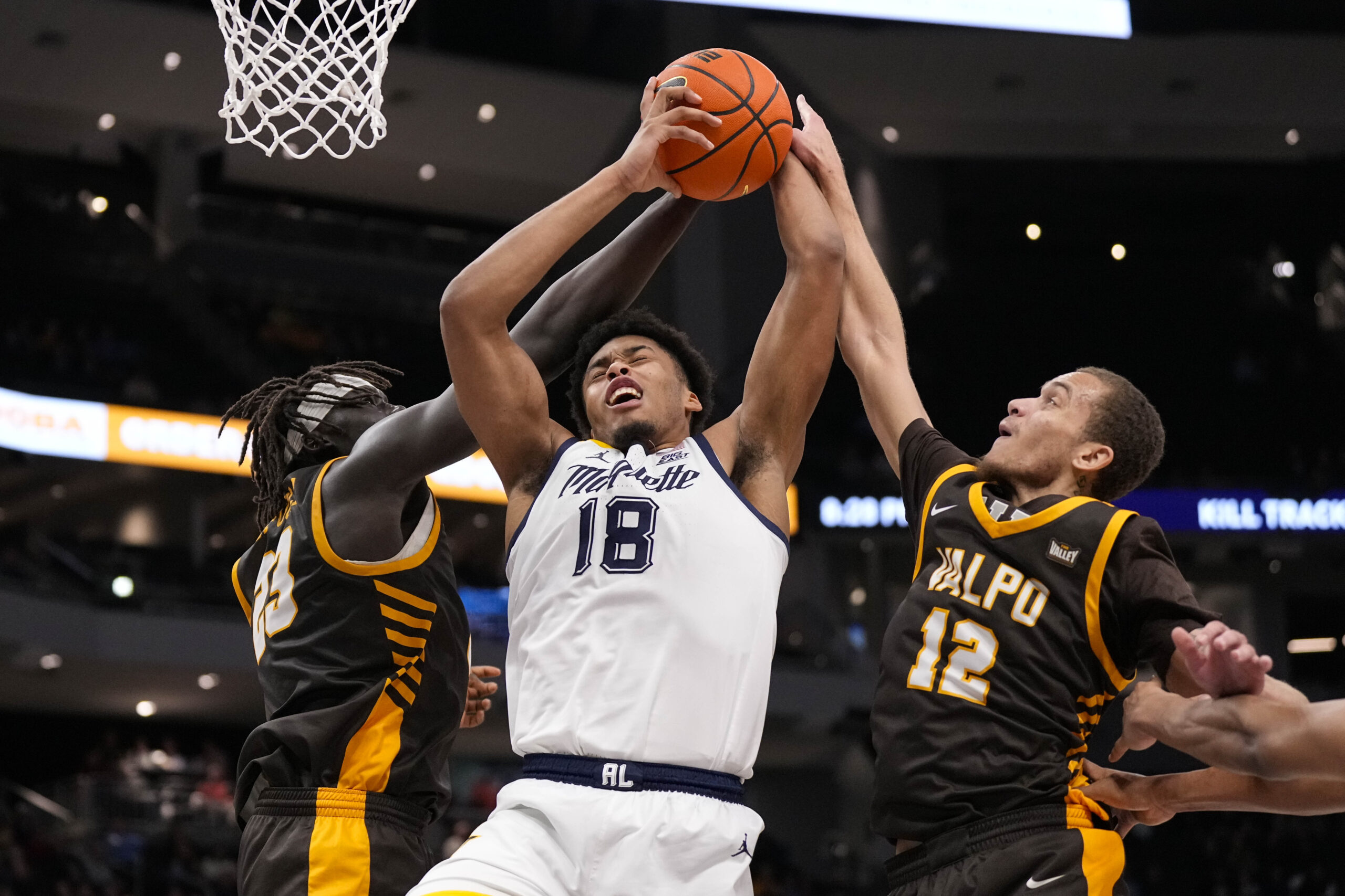 Dec 2, 2025; Milwaukee, Wisconsin, USA;  Marquette Golden Eagles forward Caedin Hamilton (18) grabs a rebound between Valparaiso Beacons center Shon Tupuola (23) and forward Owen Dease (12) during the second half at Fiserv Forum. Mandatory Credit: Jeff Hanisch-Imagn Images