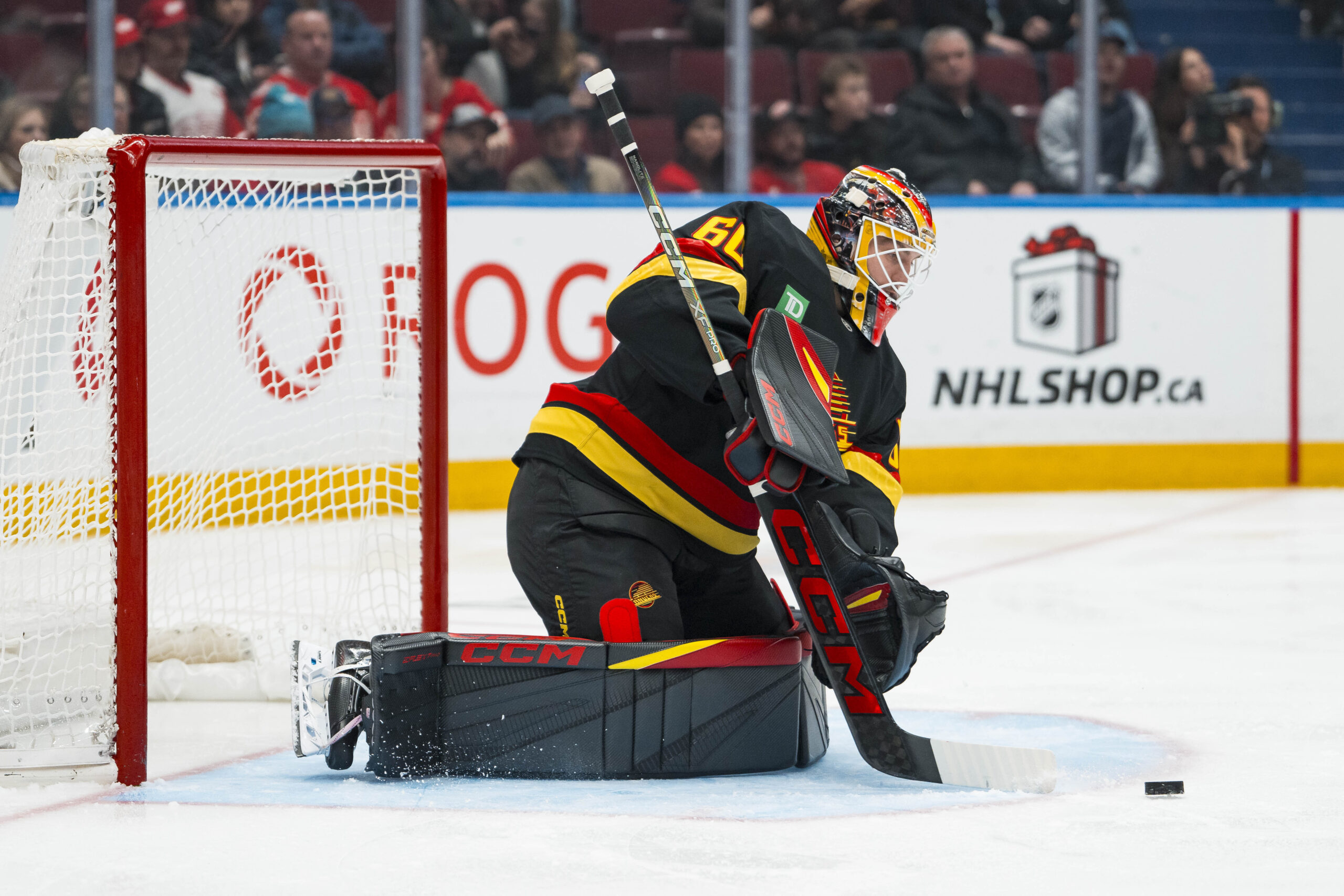 Dec 8, 2025; Vancouver, British Columbia, CAN; Vancouver Canucks goalie Nikita Tolopilo (60) makes a save against the Detroit Red Wings in the third period at Rogers Arena. Mandatory Credit: Bob Frid-Imagn Images