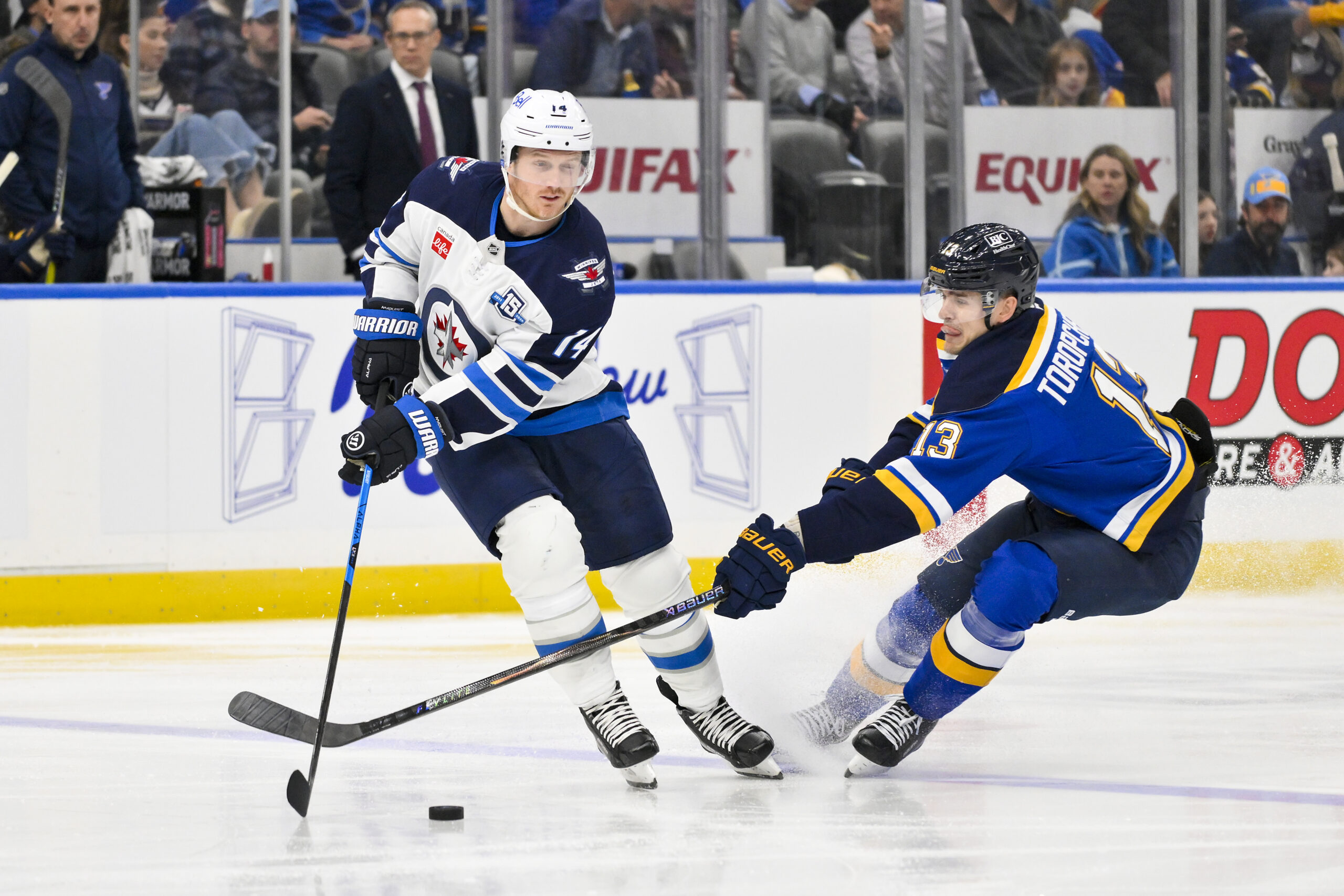 Dec 17, 2025; St. Louis, Missouri, USA; Winnipeg Jets right wing Gustav Nyquist (14) controls the puck as St. Louis Blues right wing Alexey Toropchenko (13) defends during the second period at Enterprise Center. Mandatory Credit: Jeff Curry-Imagn Images