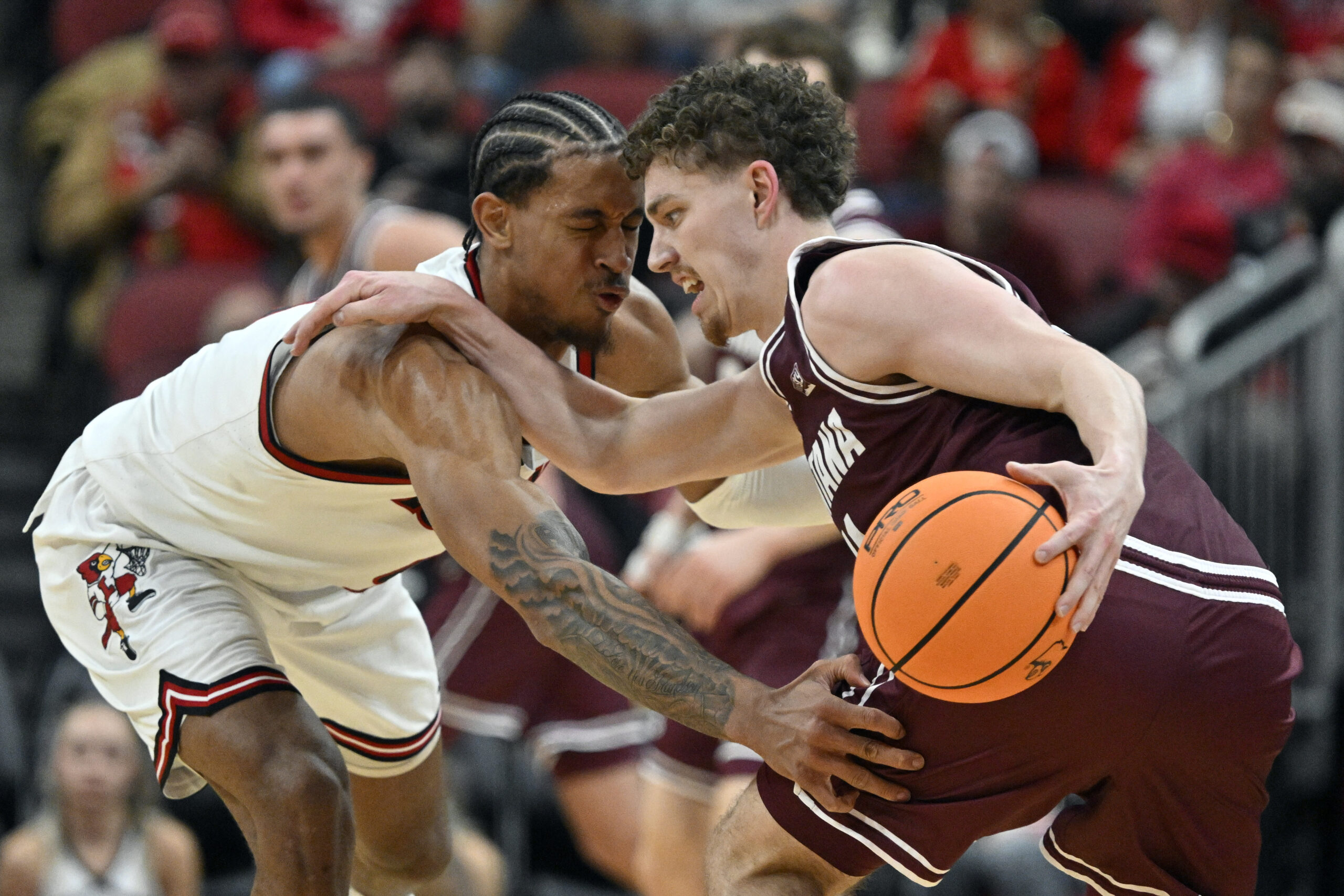 Dec 20, 2025; Louisville, Kentucky, USA;  Montana Grizzlies guard Grant Kepley (11) dribbles under the pressure of Louisville Cardinals forward Khani Rooths (9) during the second half at KFC Yum! Center. Louisville defeated Montana 94-54. Mandatory Credit: Jamie Rhodes-Imagn Images