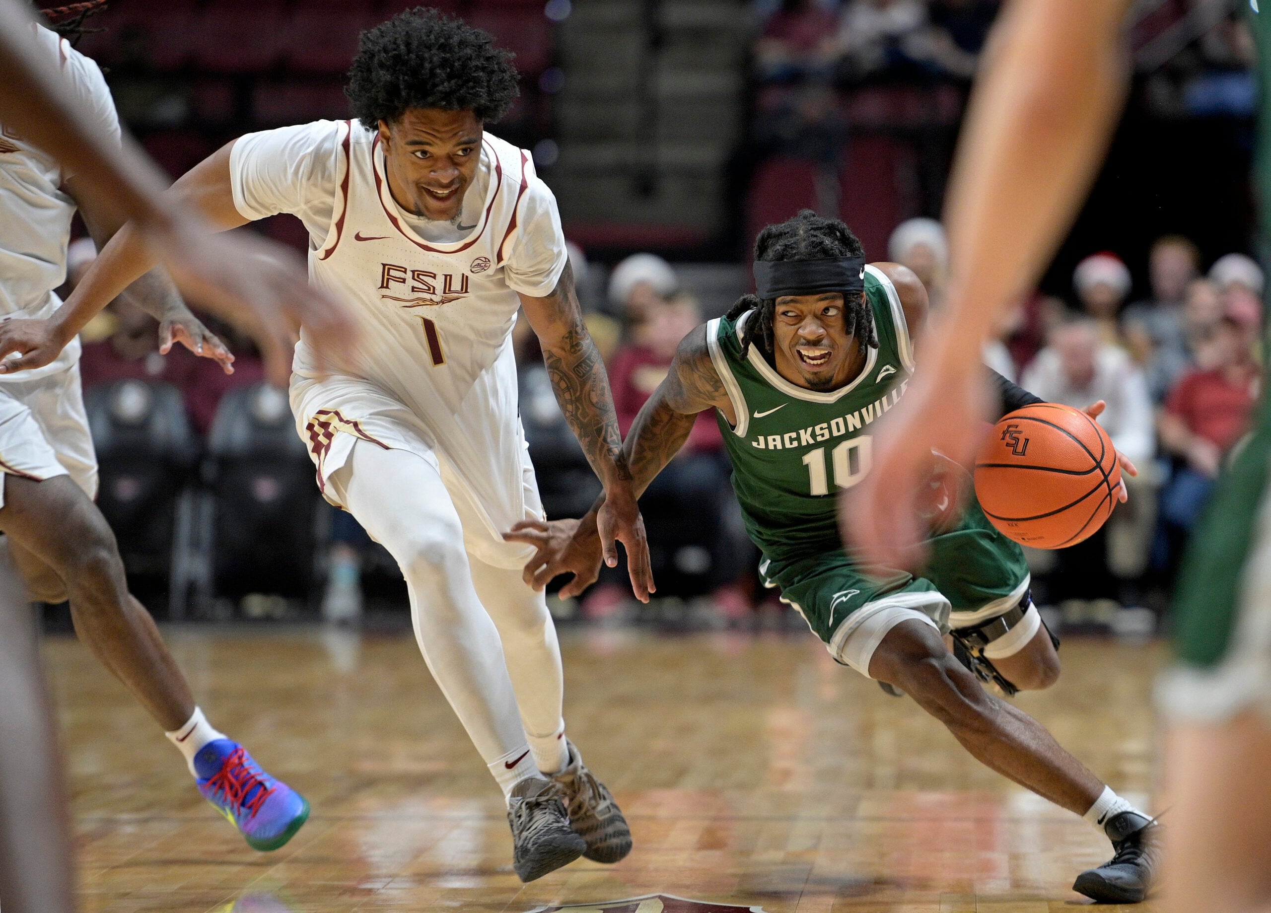 Dec 22, 2025; Tallahassee, Florida, USA; Jacksonville University Dolphins guard Simon Wheeler (1) drives the ball forward against Florida State Seminoles guard Martin Somerville (1) during the second half at Donald L. Tucker Center. Mandatory Credit: Melina Myers-Imagn Images