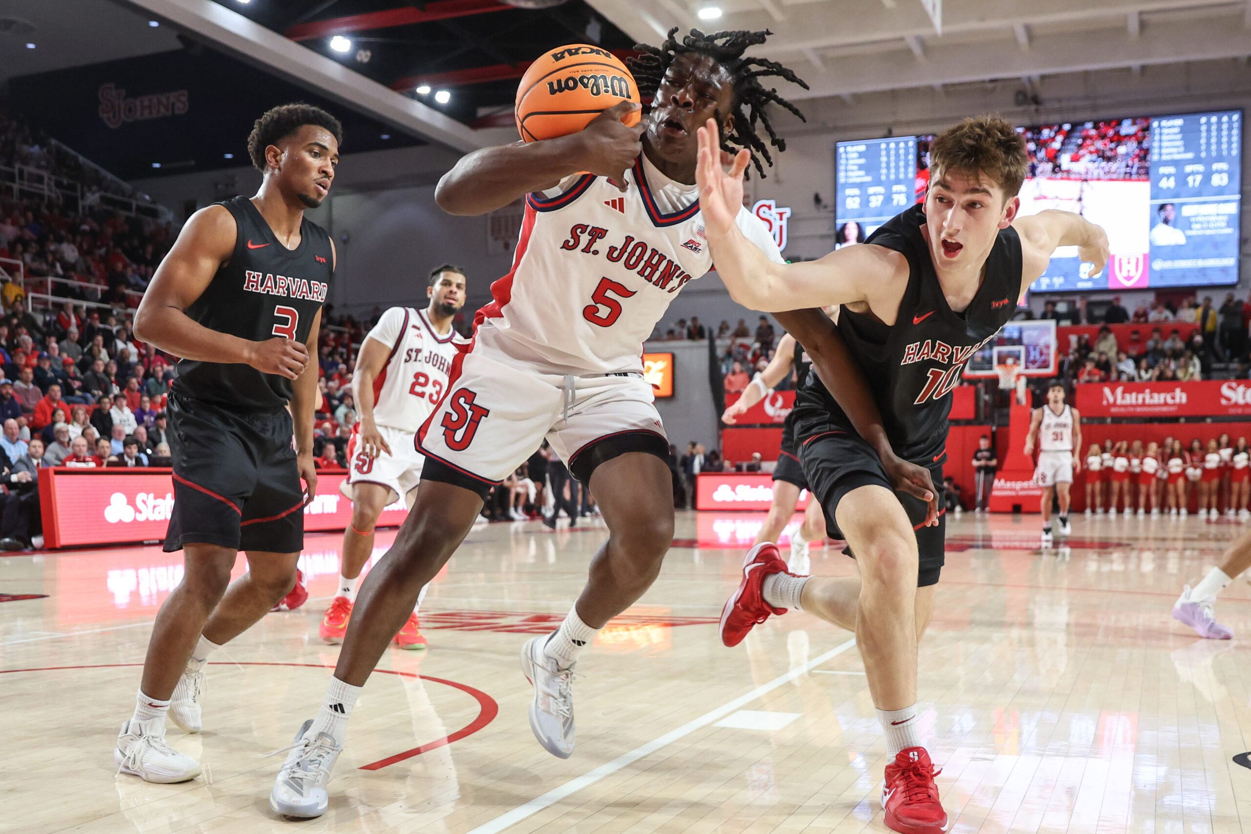 Dec 23, 2025; Queens, New York, USA;  St. John's Red Storm guard Kelvin Odih (5) and Harvard Crimson guard Frankie Mannino (10) fight for a loose ball in the second half at Carnesecca Arena. Mandatory Credit: Wendell Cruz-Imagn Images