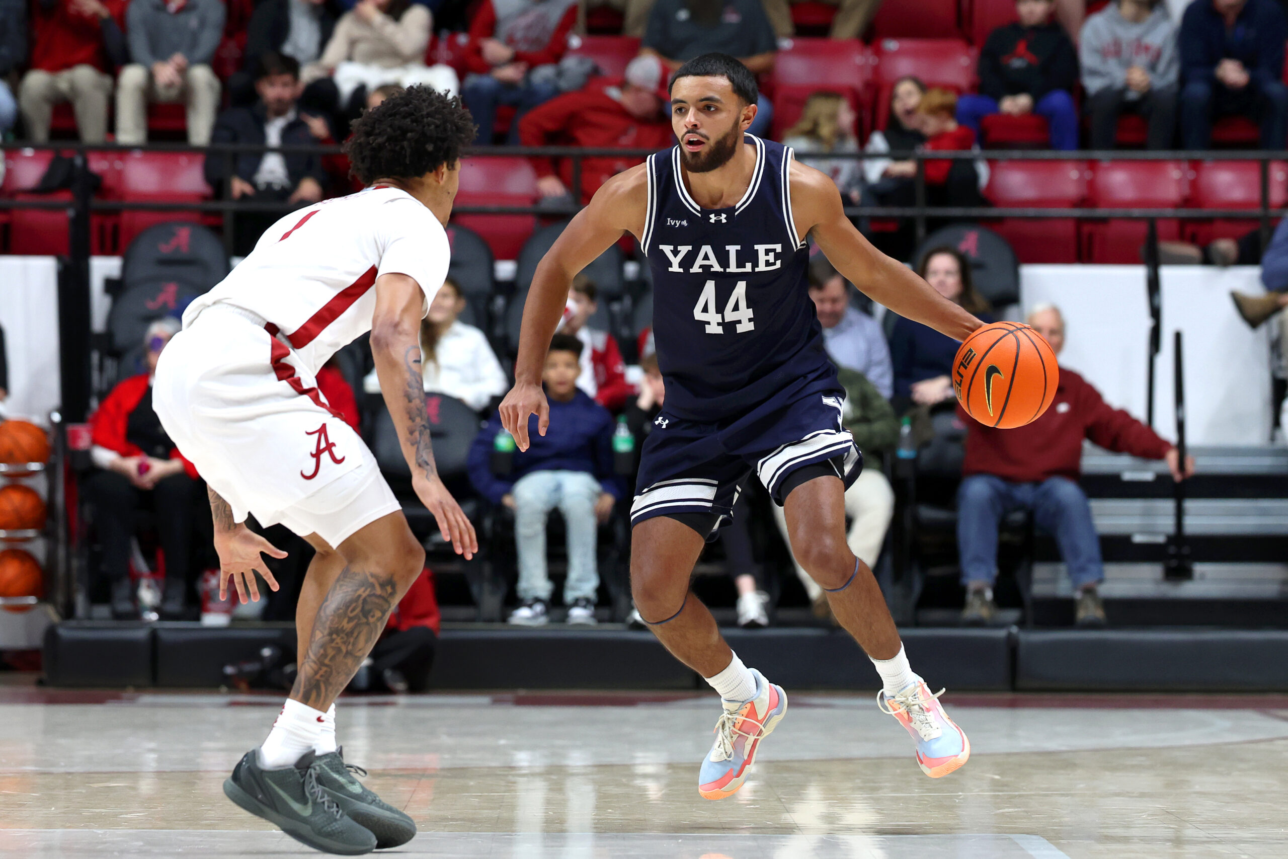 Dec 29, 2025; Tuscaloosa, Alabama, USA; Yale Bulldogs guard Devon Arlington (44) dribbles against Alabama Crimson Tide guard Jalil Bethea (1) during the second half at Coleman Coliseum. Mandatory Credit: David Leong-Imagn Images