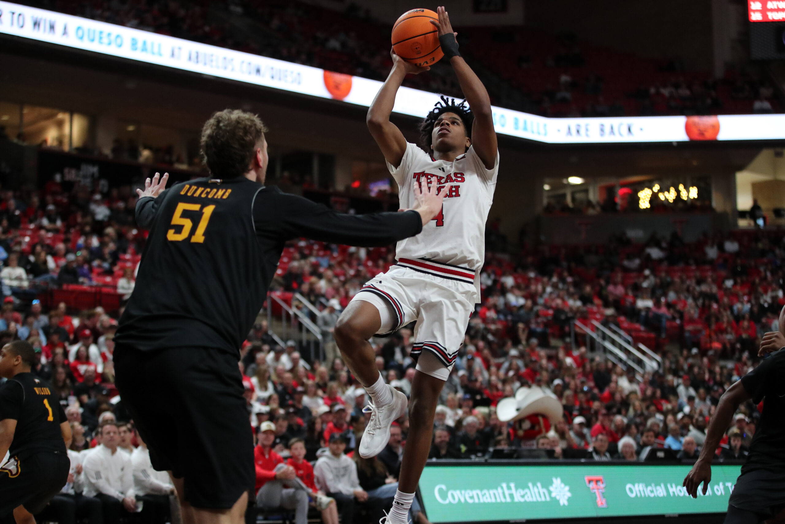 Dec 28, 2025; Lubbock, Texas, USA;  Texas Tech Red Raiders guard Christian Anderson (4) goes to the basket against Winthrop Eagles center Logan Duncomb (51) in the second half at United Supermarkets Arena. Mandatory Credit: Michael C. Johnson-Imagn Images
