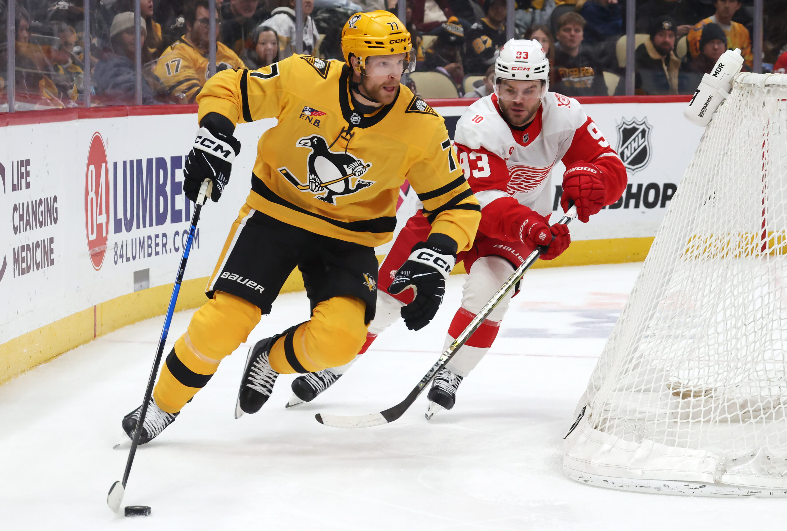 Jan 1, 2026; Pittsburgh, Pennsylvania, USA;  Pittsburgh Penguins defenseman Brett Kulak (77) moves the puck as Detroit Red Wings right wing Alex Debrincat (93) chases during the third period at PPG Paints Arena. Mandatory Credit: Charles LeClaire-Imagn Images