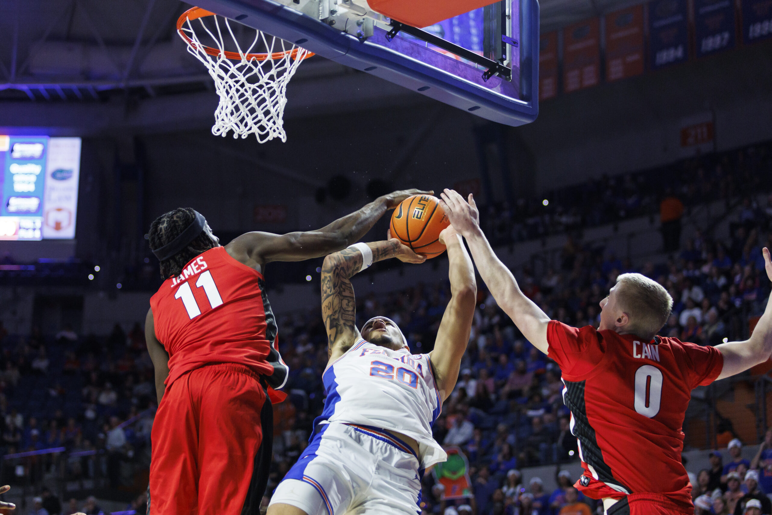 Jan 6, 2026; Gainesville, Florida, USA; Florida Gators guard Isaiah Brown (20) is fouled by Georgia Bulldogs forward Dylan James (11) during the second half at Exactech Arena at the Stephen C. O'Connell Center. Mandatory Credit: Morgan Tencza-Imagn Images