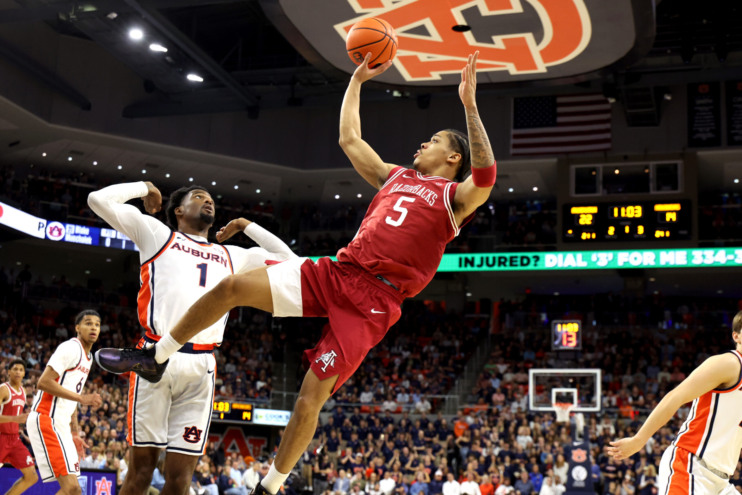 Jan 10, 2026; Auburn, Alabama, USA;  Arkansas Razorbacks guard Darius Acuff Jr. (5) gets a shot off after being fouled by Auburn Tigers guard Kevin Overton (1) during the first half at Neville Arena. Mandatory Credit: John Reed-Imagn Images