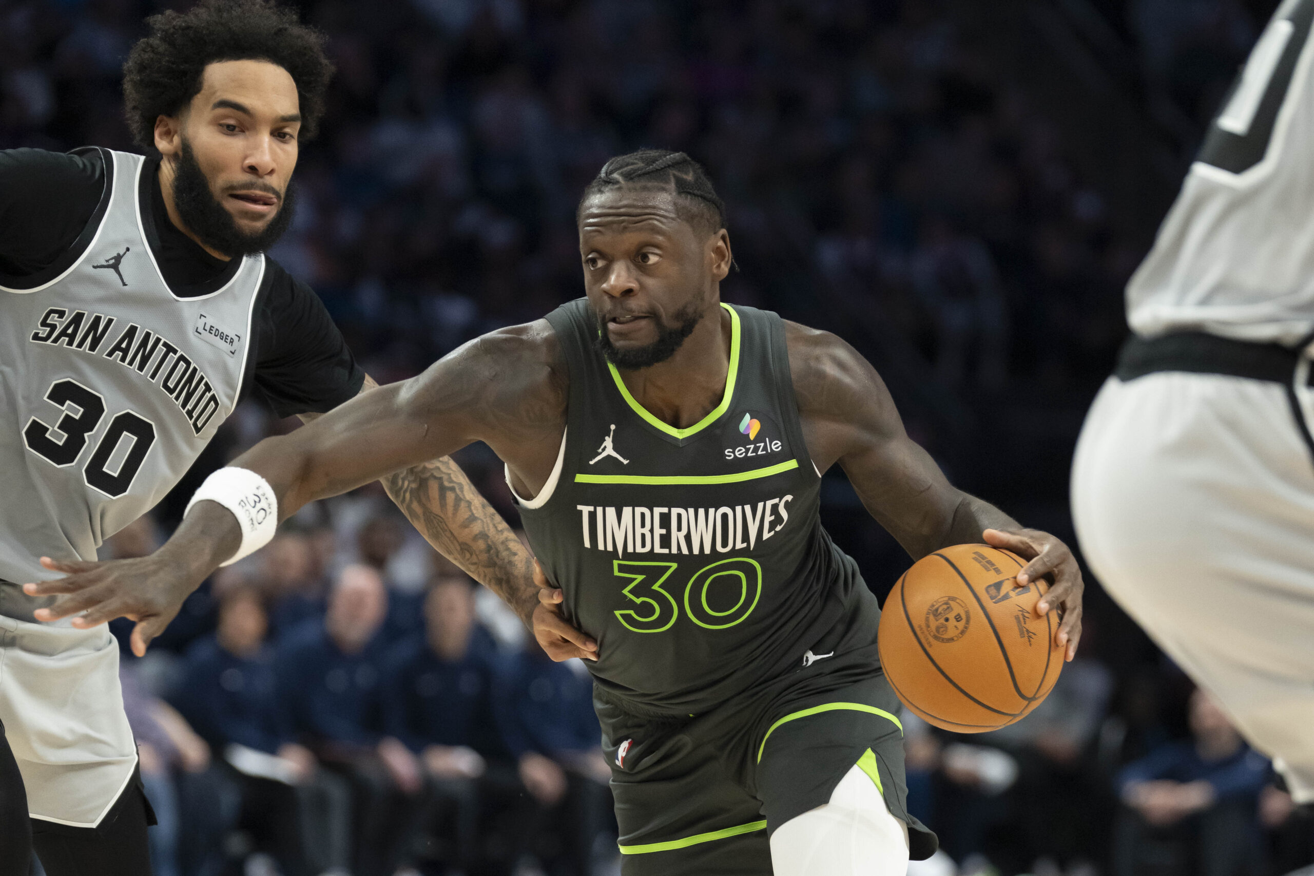 Jan 11, 2026; Minneapolis, Minnesota, USA; Minnesota Timberwolves forward Julius Randle (30) dribbles the ball past San Antonio Spurs forward Julian Champagnie (30) in the second half at Target Center. Mandatory Credit: Jesse Johnson-Imagn Images