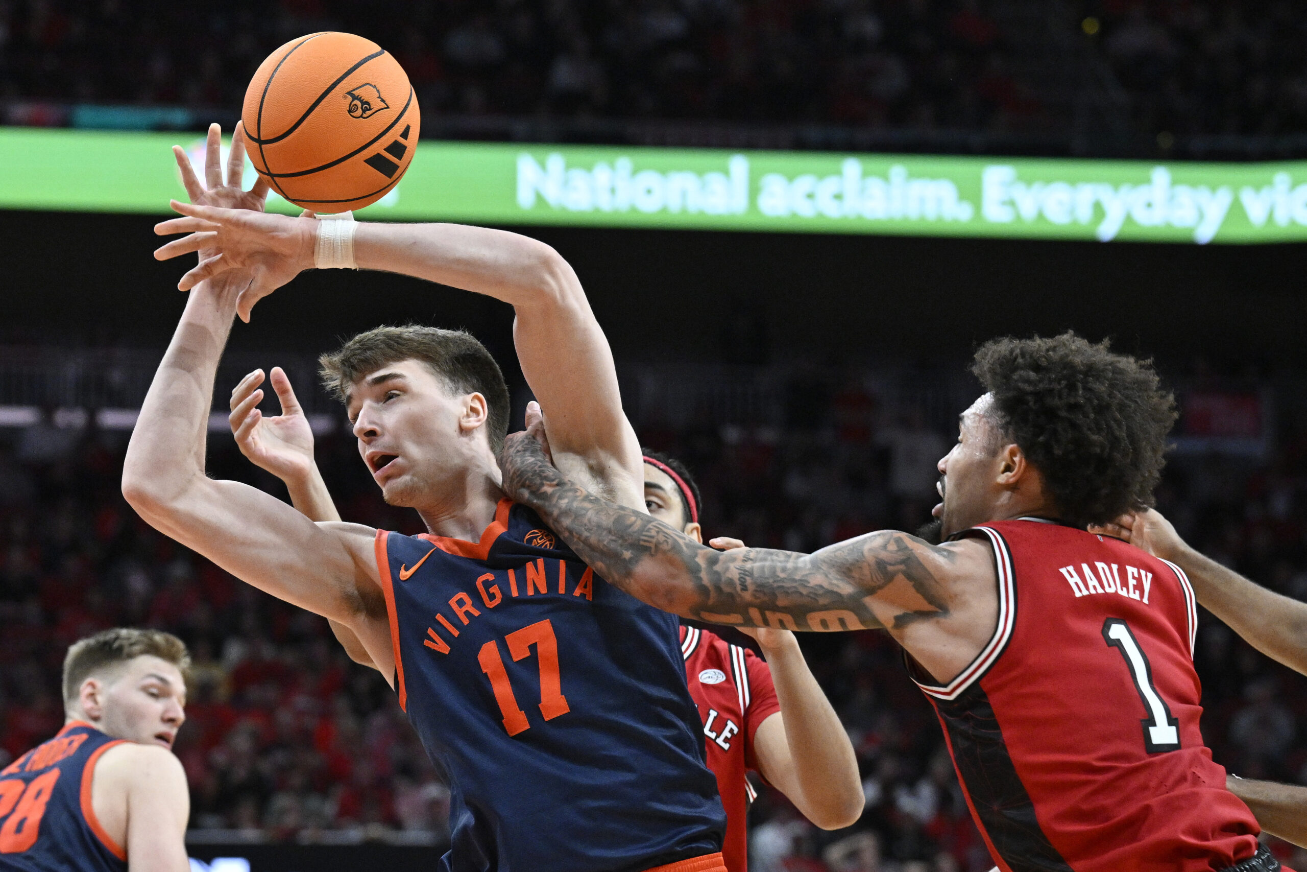 Jan 13, 2026; Louisville, Kentucky, USA; Virginia Cavaliers center Johann Gruenloh (17) draws a foul from Louisville Cardinals guard J'vonne Hadley (1) as they battle for a rebound during the second half at KFC Yum! Center. Virginia defeated Louisville 79-70. Mandatory Credit: Jamie Rhodes-Imagn Images