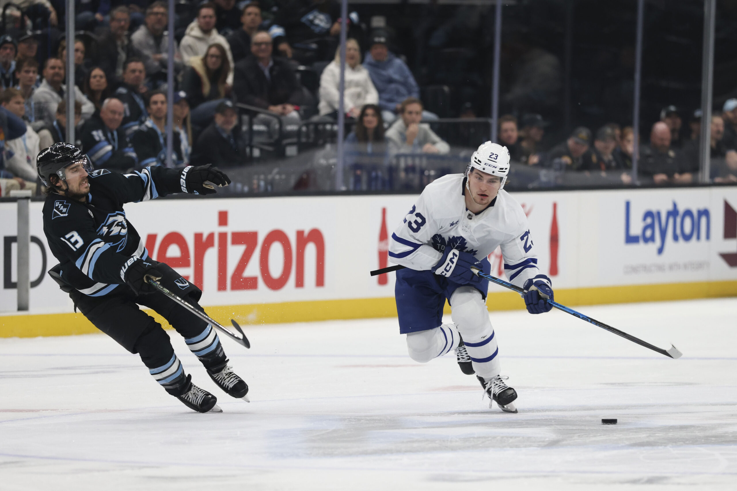Jan 13, 2026; Salt Lake City, Utah, USA; Toronto Maple Leafs left wing Matthew Knies (23) skates with the puck against Utah Mammoth left wing Brandon Tanev (13) during the first period at Delta Center. Mandatory Credit: Rob Gray-Imagn Images