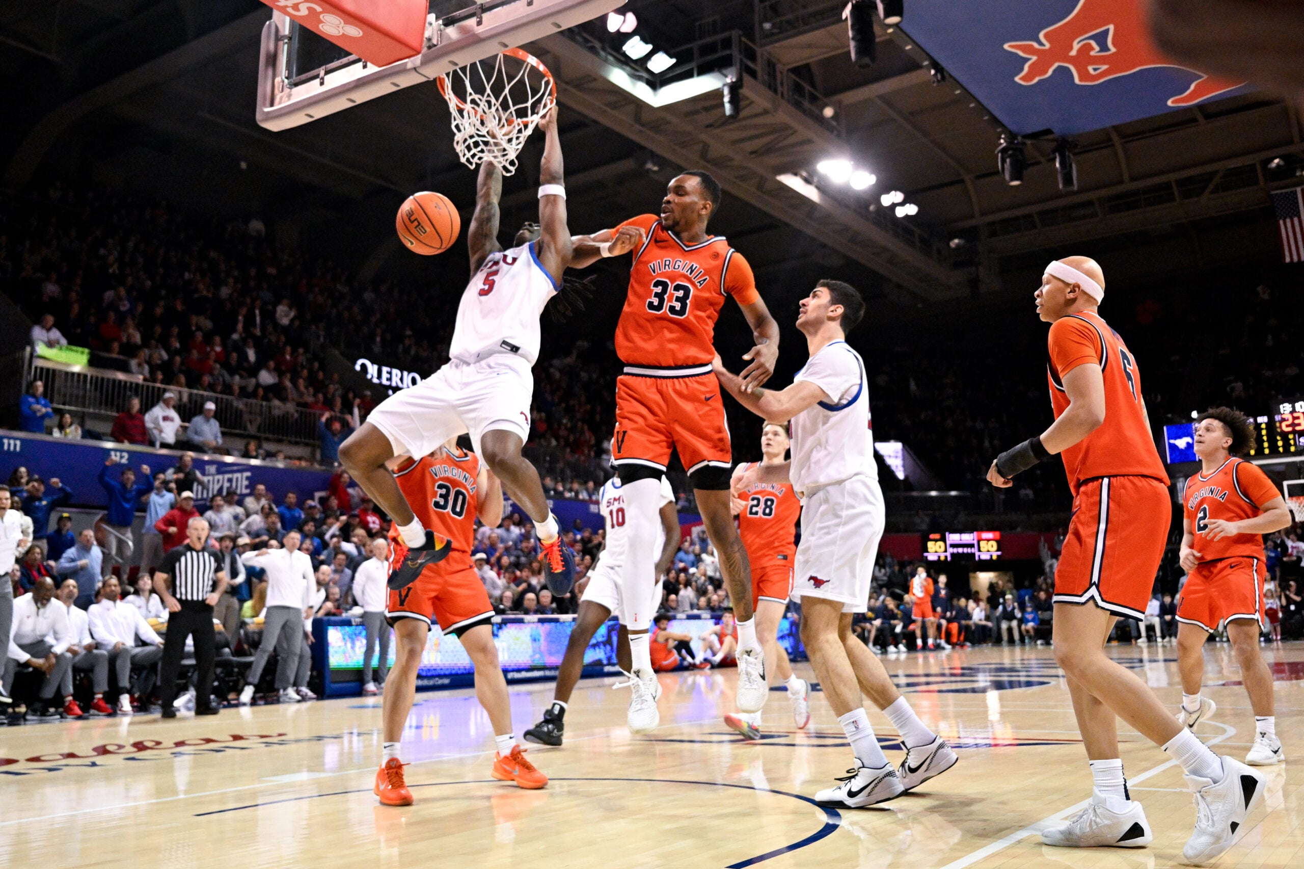 Jan 17, 2026; Dallas, Texas, USA; SMU Mustangs guard Jaron Pierre Jr. (5) dunks  the ball past Virginia Cavaliers center Ugonna Onyenso (33) during the second half at Moody Coliseum. Mandatory Credit: Jerome Miron-Imagn Images
