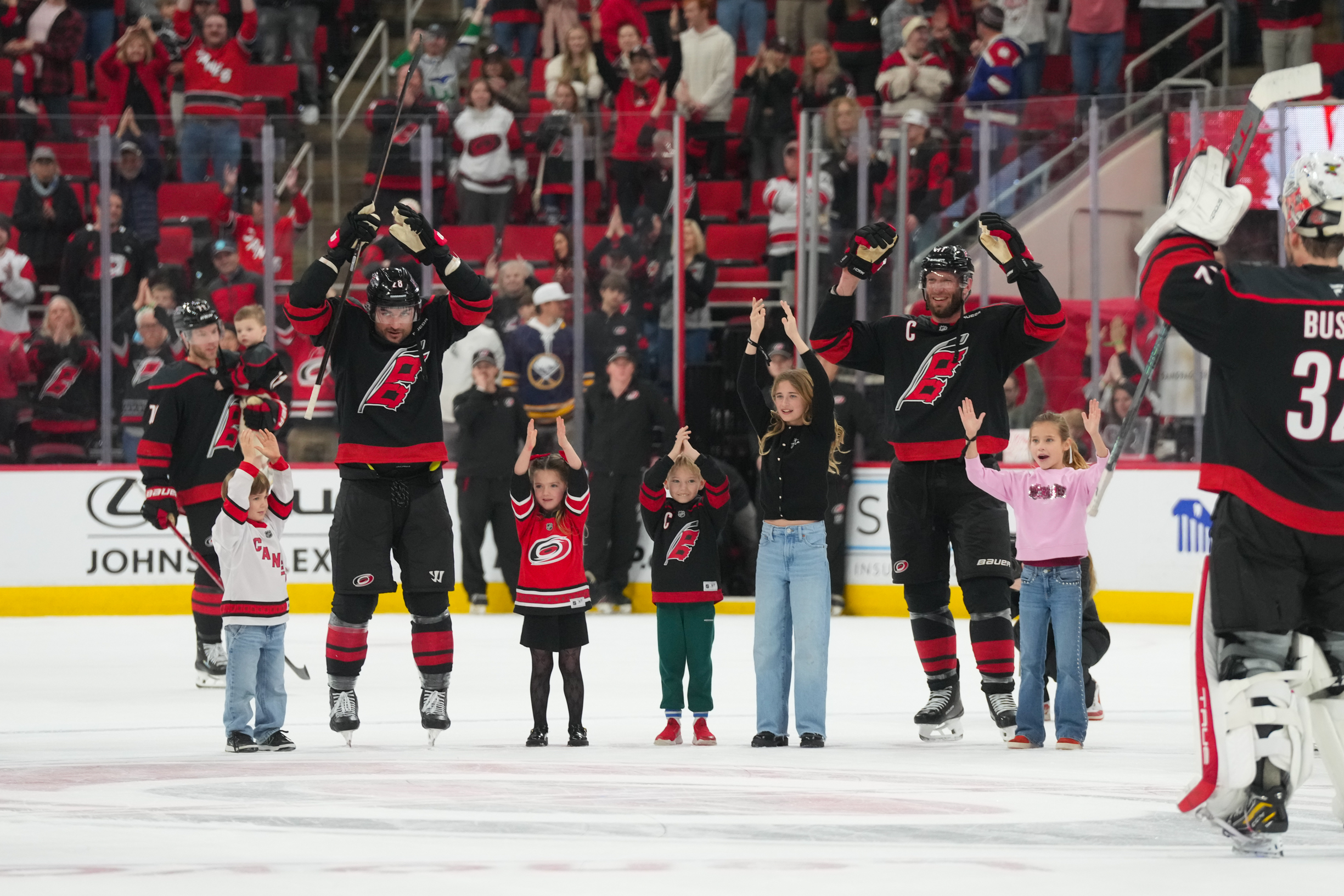 Jan 19, 2026; Raleigh, North Carolina, USA;  Carolina Hurricanes center Jordan Staal (11) and left wing William Carrier (28) celebrates their victory with the kids against the Buffalo Sabres at Lenovo Center. Mandatory Credit: James Guillory-Imagn Images