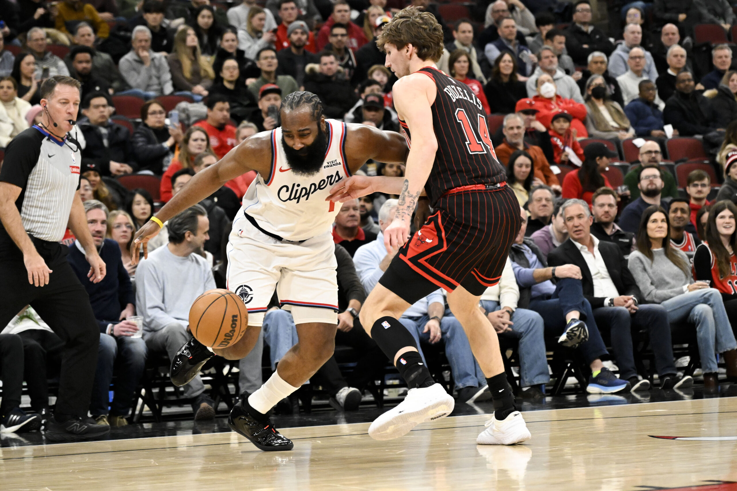 Jan 20, 2026; Chicago, Illinois, USA; LA Clippers guard James Harden (1) drives against Chicago Bulls forward Matas Buzelis (14) during the first half at United Center. Mandatory Credit: Matt Marton-Imagn Images