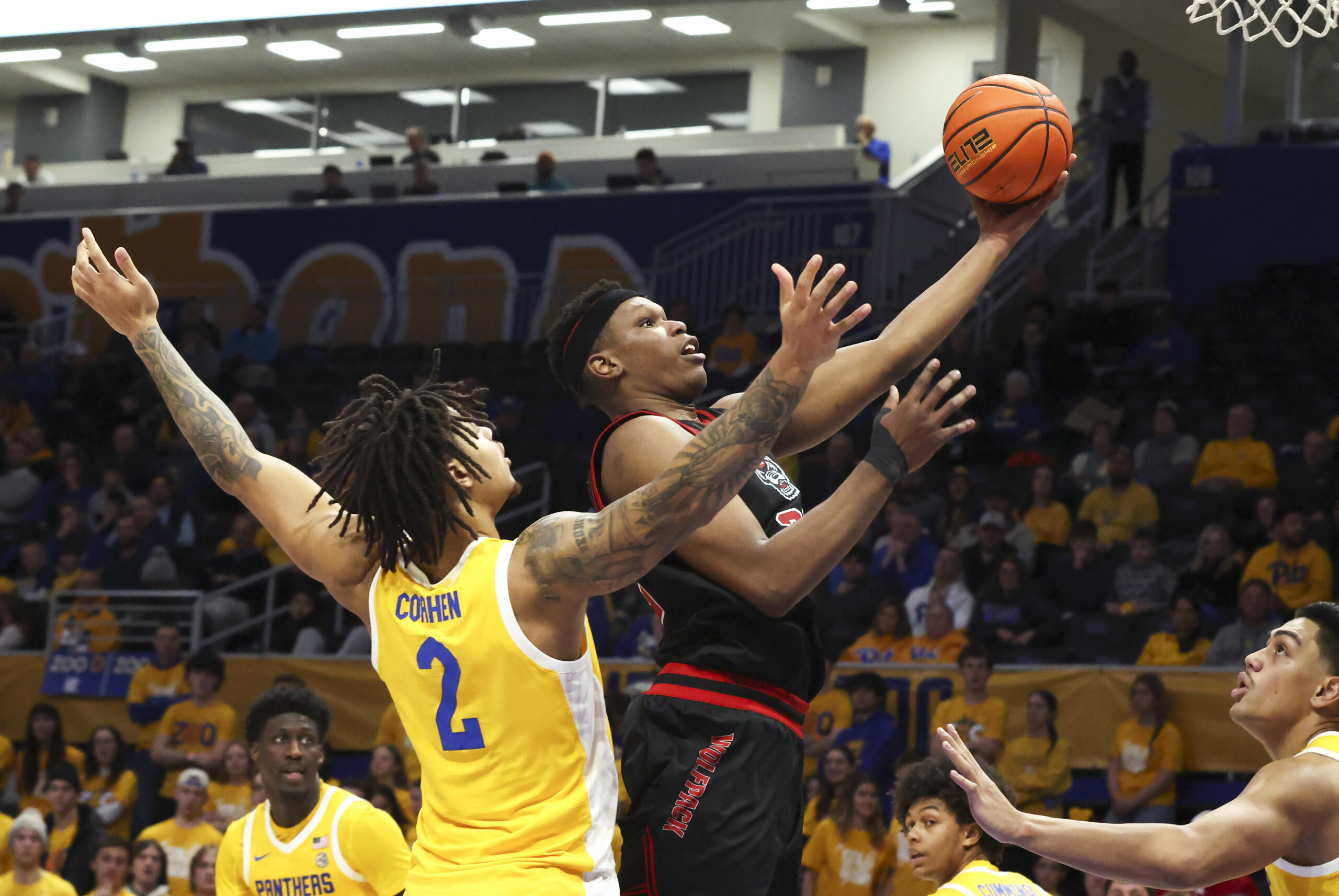 Jan 24, 2026; Pittsburgh, Pennsylvania, USA;  NC State Wolfpack forward Ven-Allen Lubin (right) goes to the basket against Pittsburgh Panthers forward Cameron Corhen (2) during the second half at the Petersen Events Center. Mandatory Credit: Charles LeClaire-Imagn Images