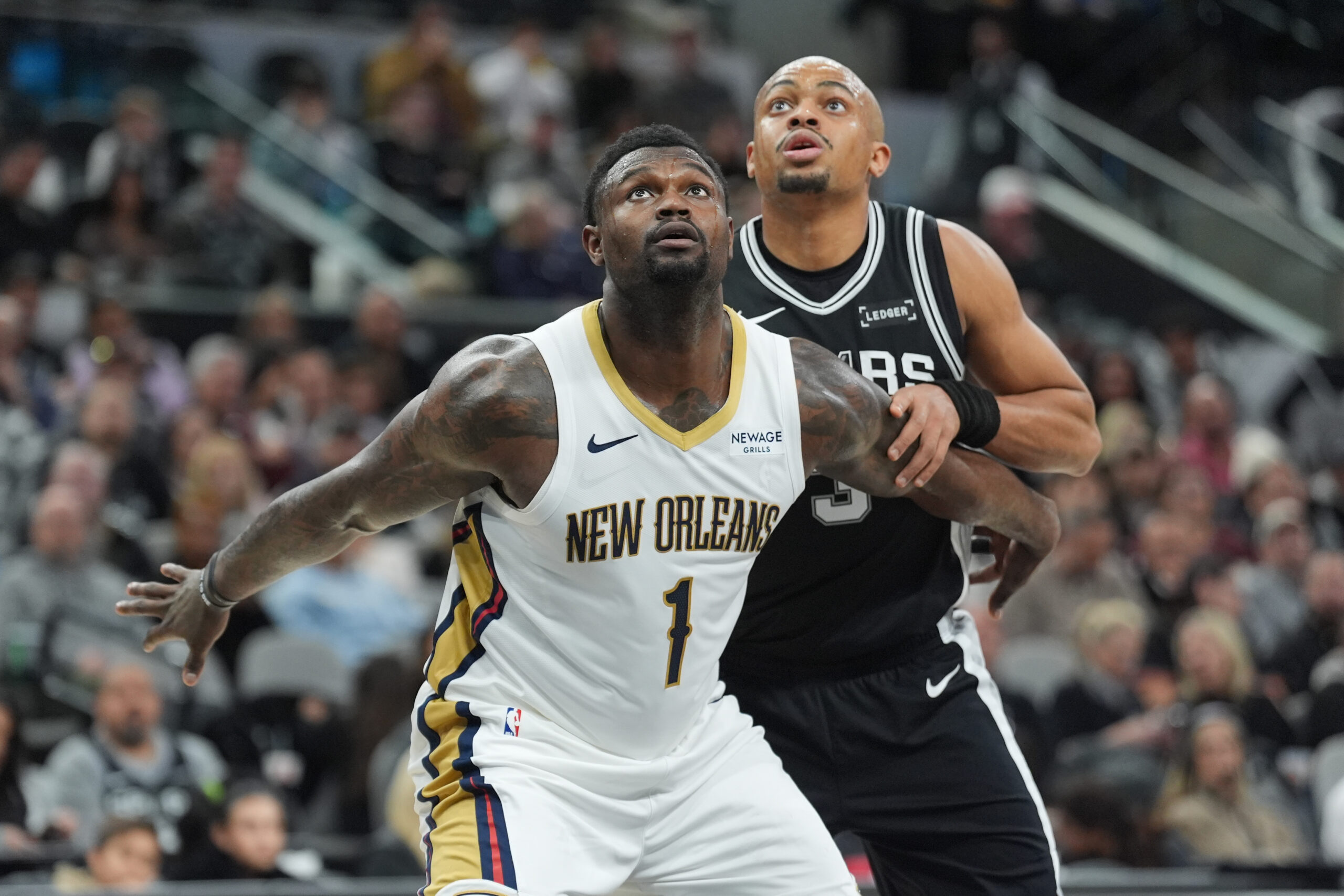 Jan 25, 2026; San Antonio, Texas, USA;  New Orleans Pelicans forward Zion Williamson (1) and San Antonio Spurs forward Keldon Johnson (3) looks up for a rebound in the first at Frost Bank Center. Mandatory Credit: Daniel Dunn-Imagn Images