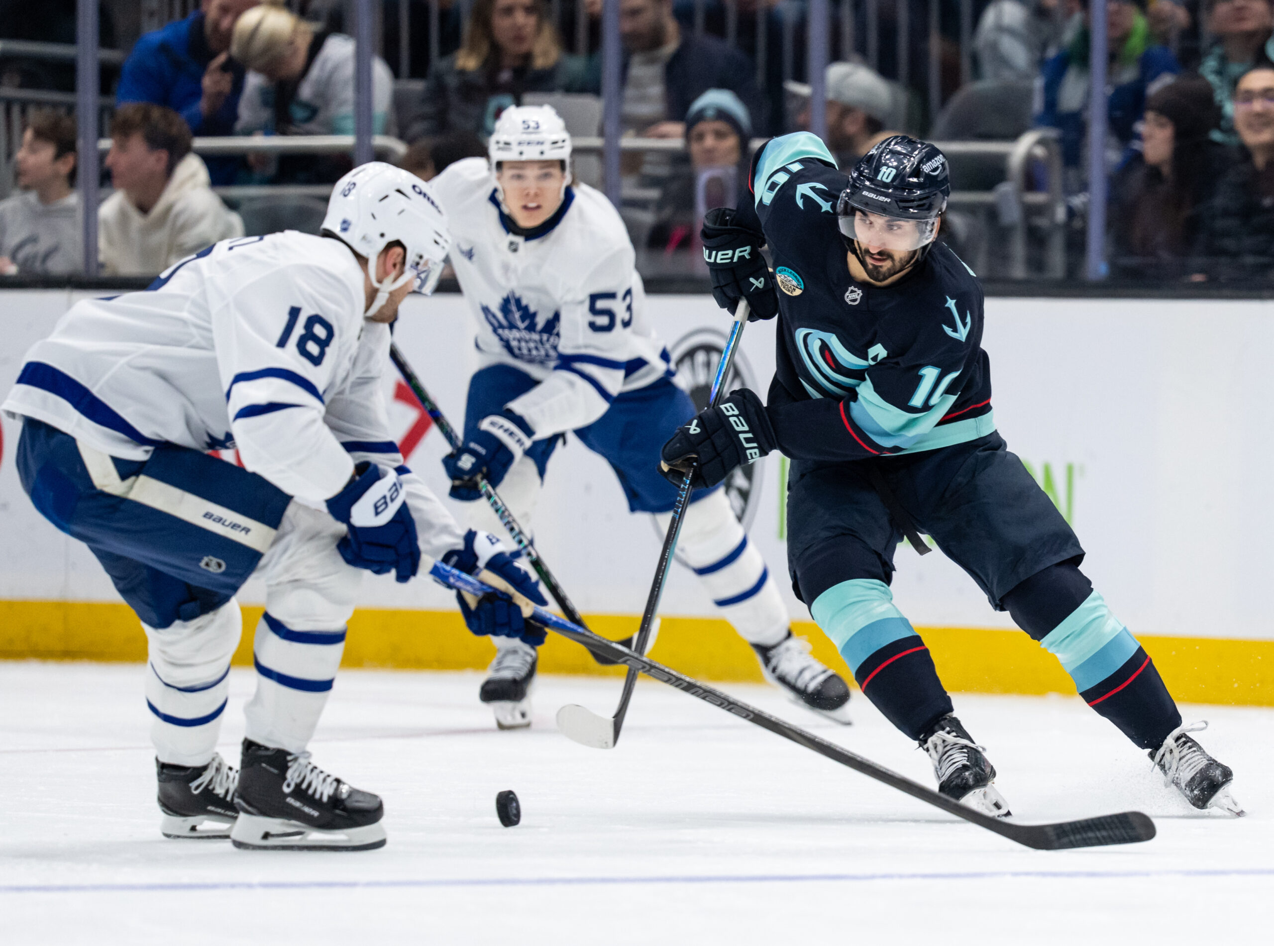 Jan 29, 2026; Seattle, Washington, USA; Seattle Kraken forward Matty Beniers (10) skates against 	 defenseman Chris Tanev (8) during the second period at Climate Pledge Arena. Mandatory Credit: Stephen Brashear-Imagn Images