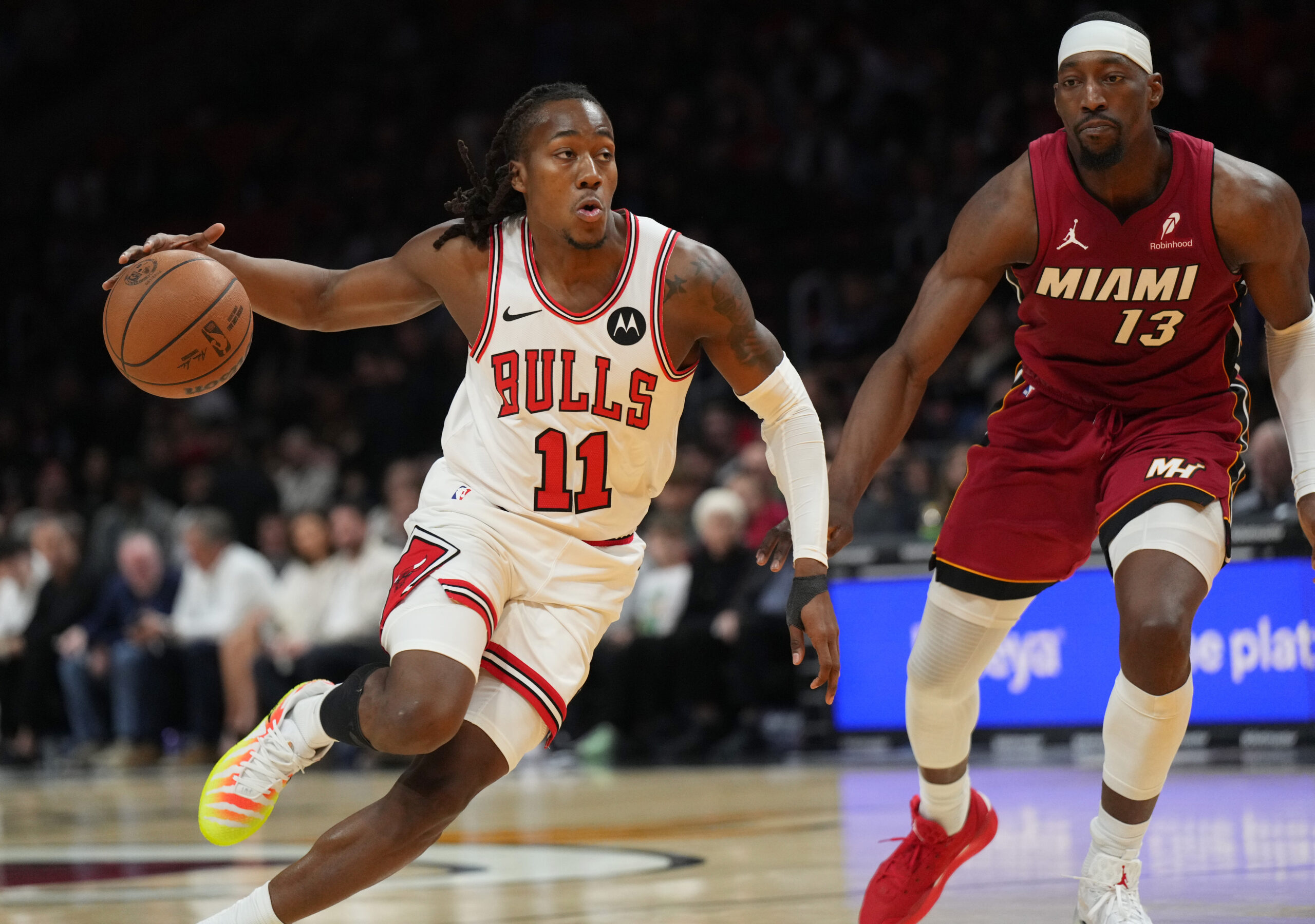 Jan 31, 2026; Miami, Florida, USA;  Chicago Bulls guard Ayo Dosunmu (11) drives to the basket as Miami Heat center Bam Adebayo (13) defends during the first half at Kaseya Center. Mandatory Credit: Jim Rassol-Imagn Images