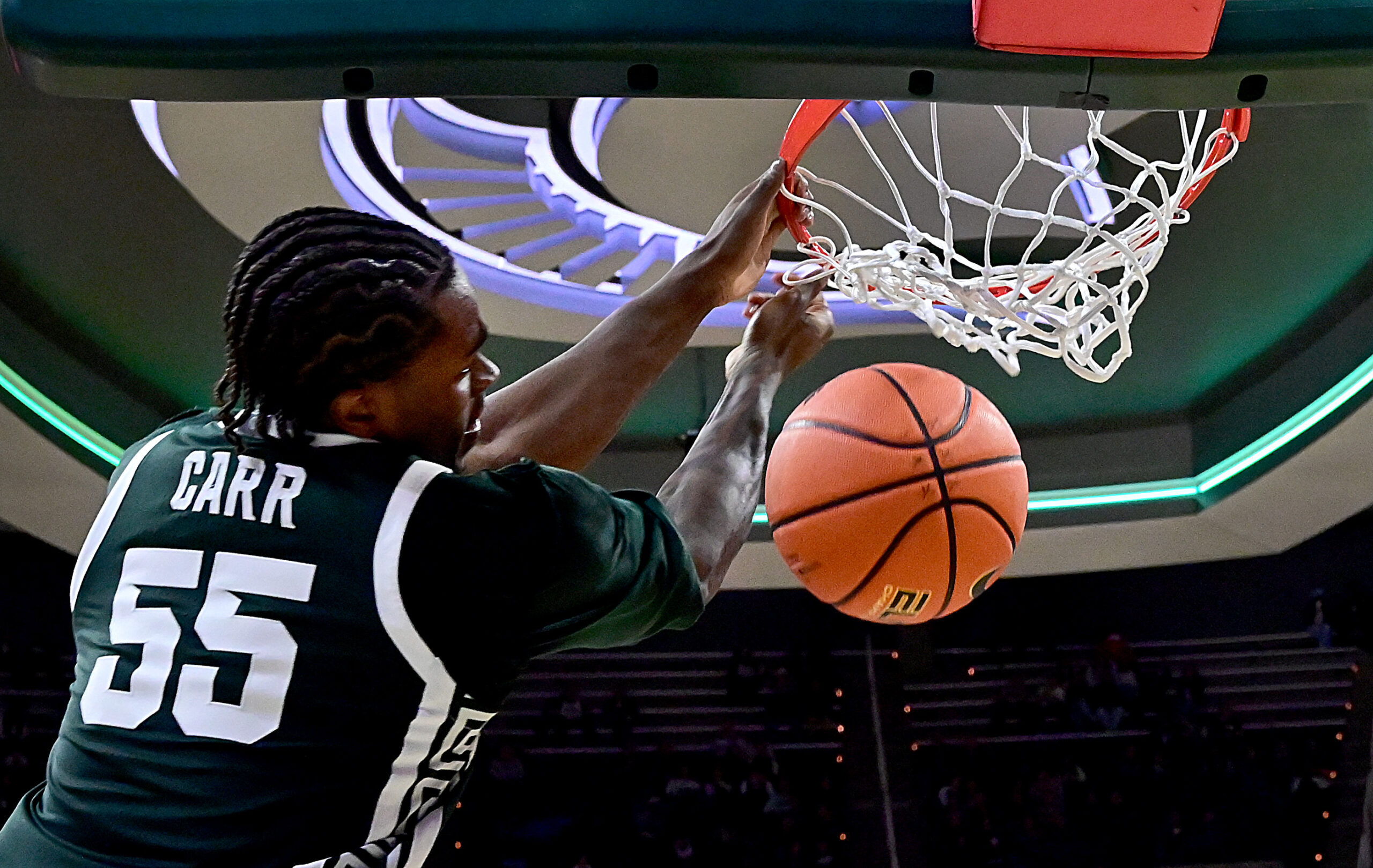 Nov 13, 2025; East Lansing, Michigan, USA; Michigan State Spartans forward Coen Carr (55) watches a second half dunk go through the net against the San Jose State Spartans at Jack Breslin Student Events Center. Mandatory Credit: Dale Young-Imagn Images