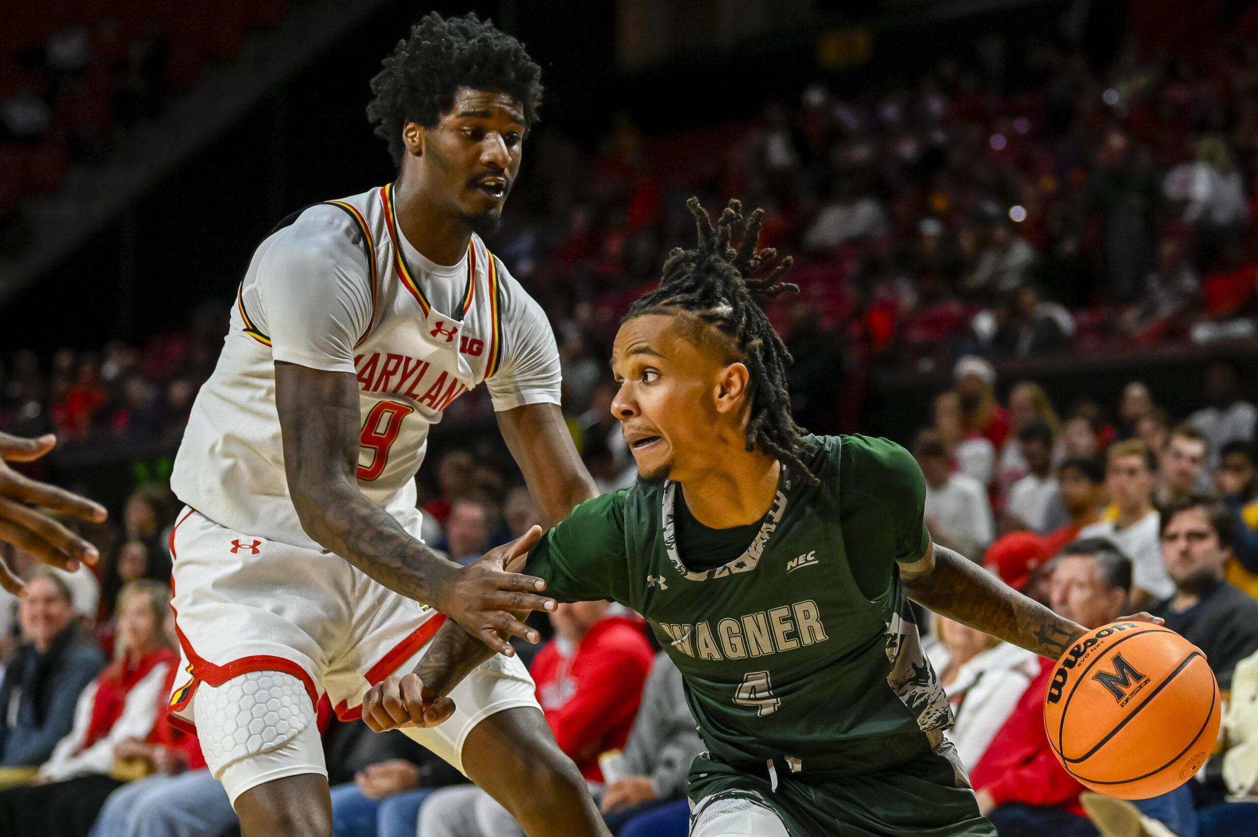 Dec 2, 2025; College Park, Maryland, USA; Wagner Seahawks guard John Awoke (4) makes a move to the basket on Maryland Terrapins forward Solomon Washington (9) during the first half at Xfinity Center. Mandatory Credit: Tommy Gilligan-Imagn Images
