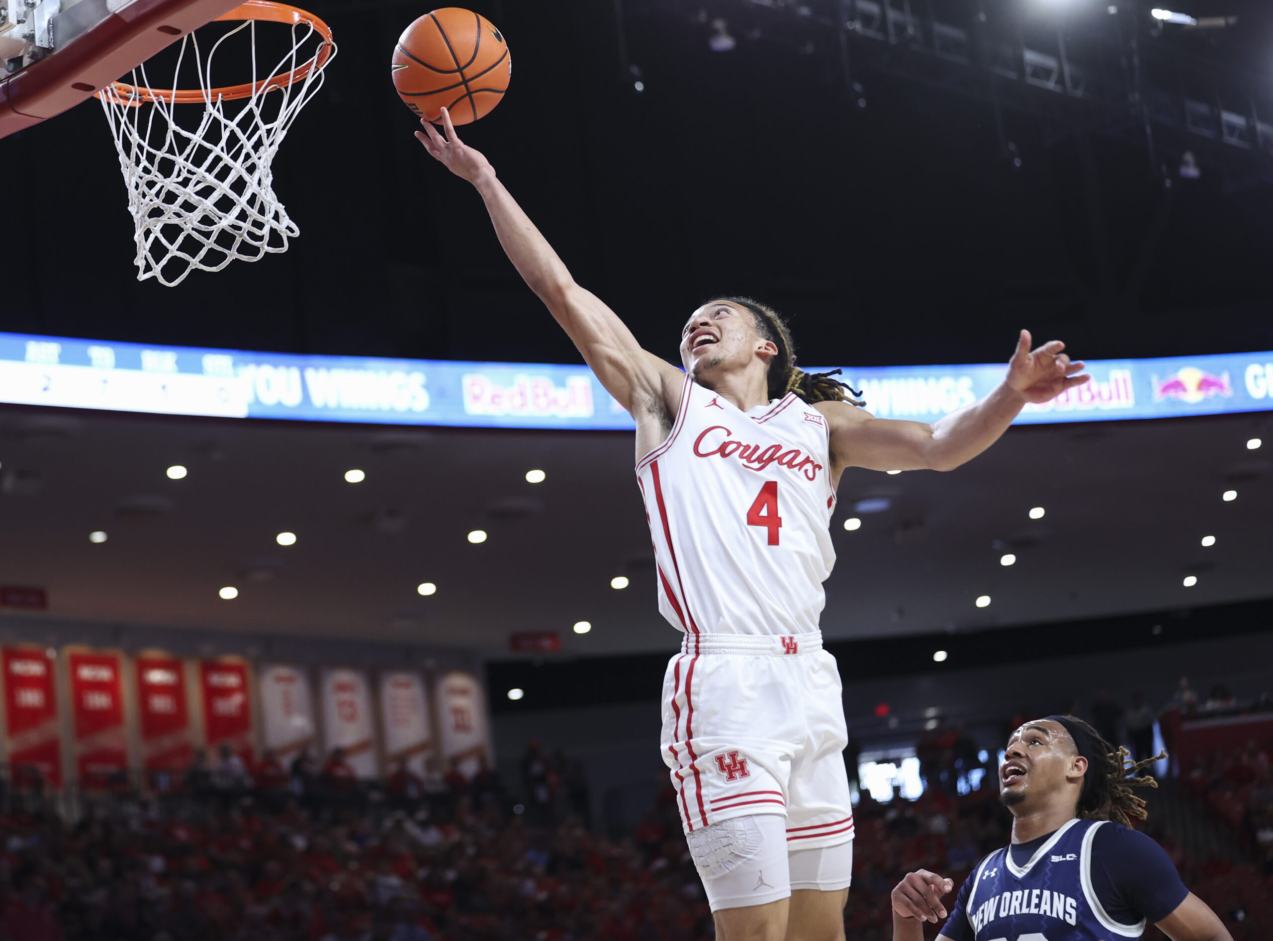 Dec 13, 2025; Houston, Texas, USA; Houston Cougars guard Kingston Flemings (4) scores a basket as New Orleans Privateers forward MJ Thomas (23) defends during the first half at Fertitta Center. Mandatory Credit: Troy Taormina-Imagn Images