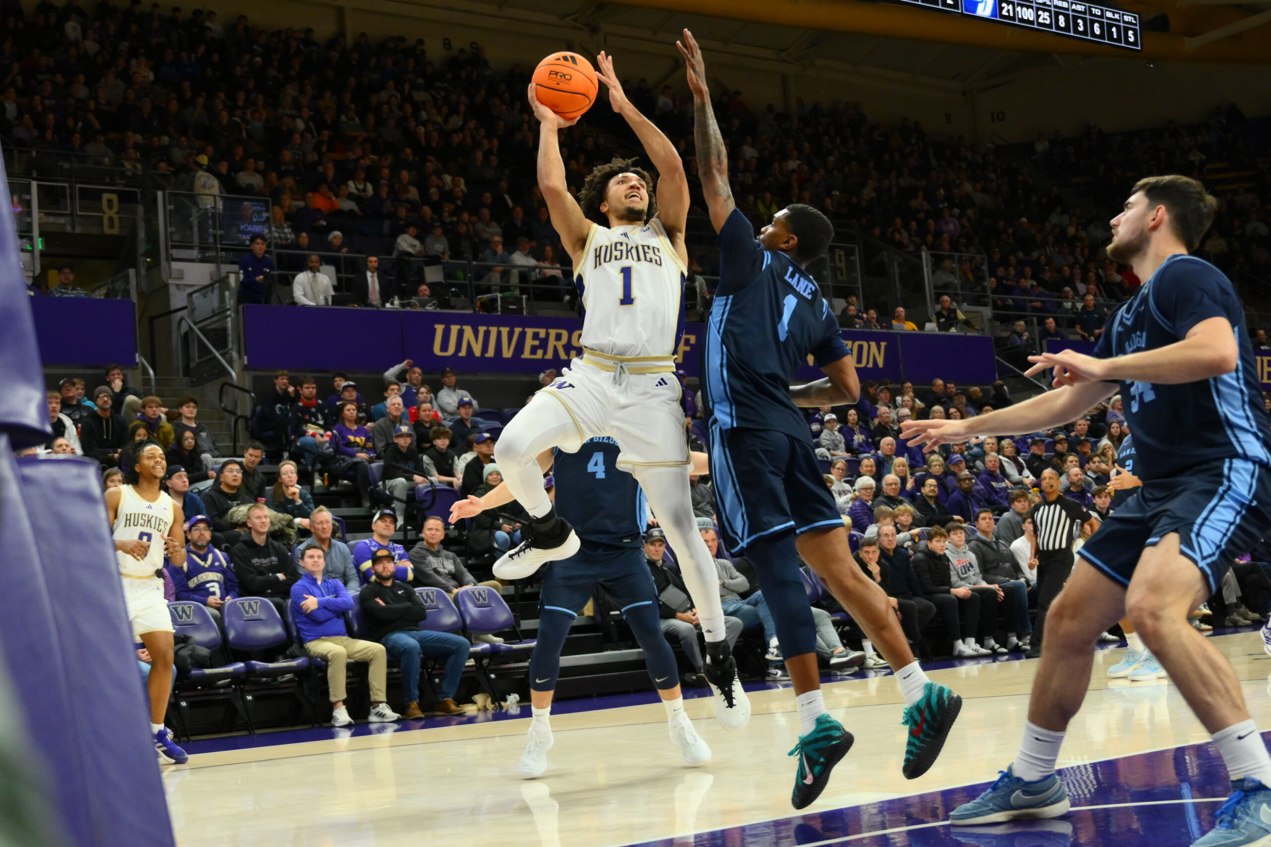 Dec 22, 2025; Seattle, Washington, USA; Washington Huskies guard Desmond Claude (1) shoots the ball while guarded by San Diego Toreros guard Toneari Lane (1) during the first half at Alaska Airlines Arena at Hec Edmundson Pavilion. Mandatory Credit: Steven Bisig-Imagn Images