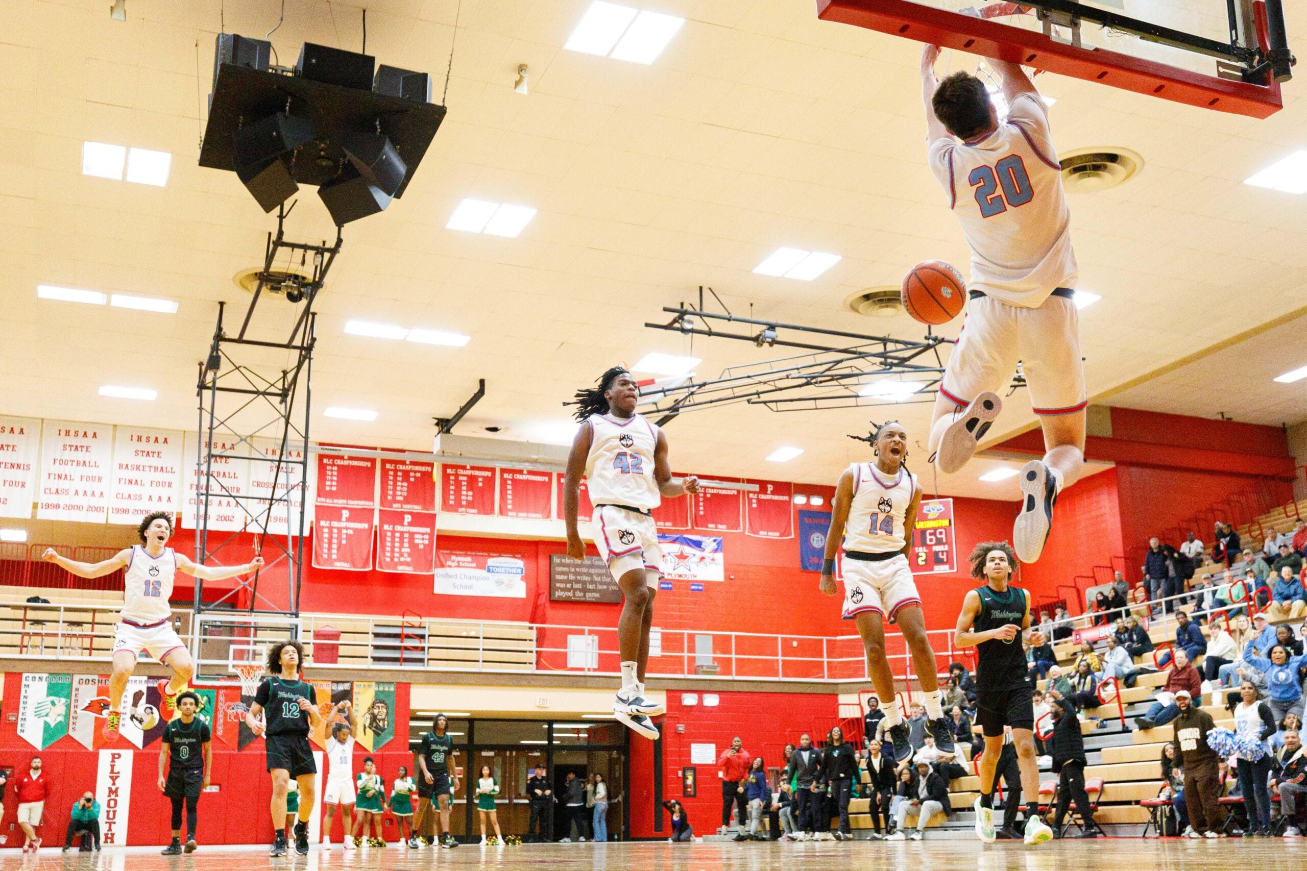 Saint Joseph's Nick Shrewsberry (12), Braylen White (42) and AJ Boone (14) celebrate as Chase Konieczny (20) dunks the ball during an IHSAA 3A Sectional boys basketball game between Saint Joseph and Washington at Plymouth High School on Wednesday, March 5, 2025, in Plymouth.