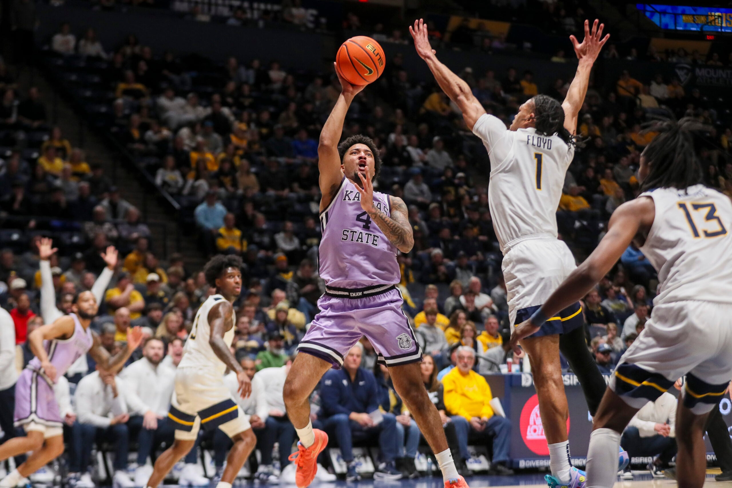 Jan 27, 2026; Morgantown, West Virginia, USA; Kansas State Wildcats guard PJ Haggerty (4) shoots in the lane against West Virginia Mountaineers guard Jasper Floyd (1) during the first half at Hope Coliseum. Mandatory Credit: Ben Queen-Imagn Imagesa