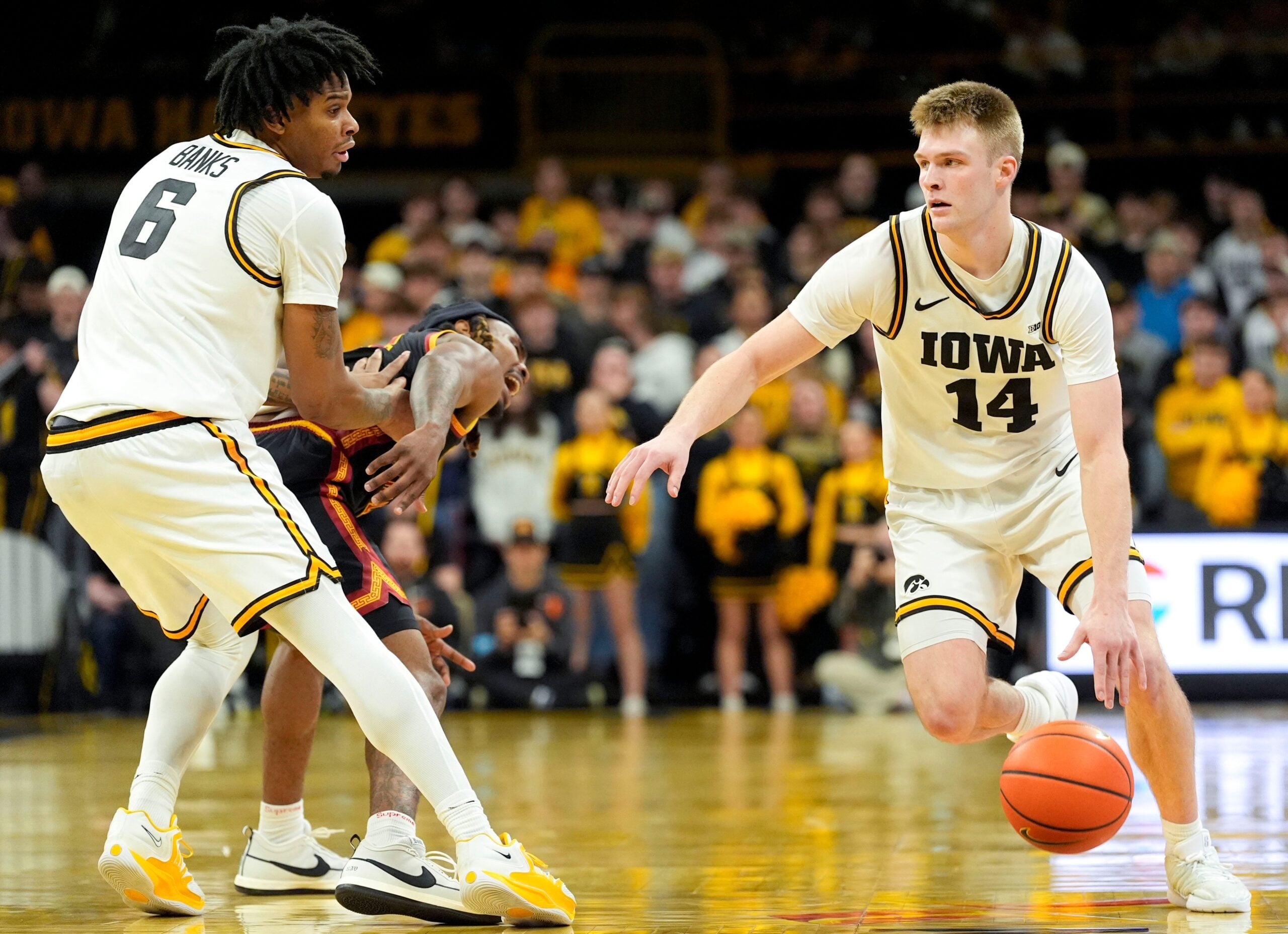 Iowa guard Bennett Stirtz (14) dribbles past Iowa’s Tavion Banks (6) as he screens USC guard Kam Woods (13) Jan. 28, 2026 at Carver-Hawkeye Arena in Iowa City, Iowa.