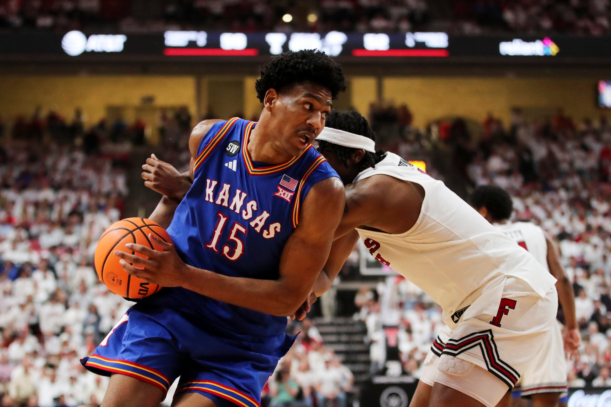 Feb 2, 2026; Lubbock, Texas, USA;  Kansas Jayhawks guard Bryson Tiller (15) drives the ball around Texas Tech Red Raiders guard Tyeree Byran (1) in the second half at United Supermarkets Arena. Mandatory Credit: Michael C. Johnson-Imagn Images