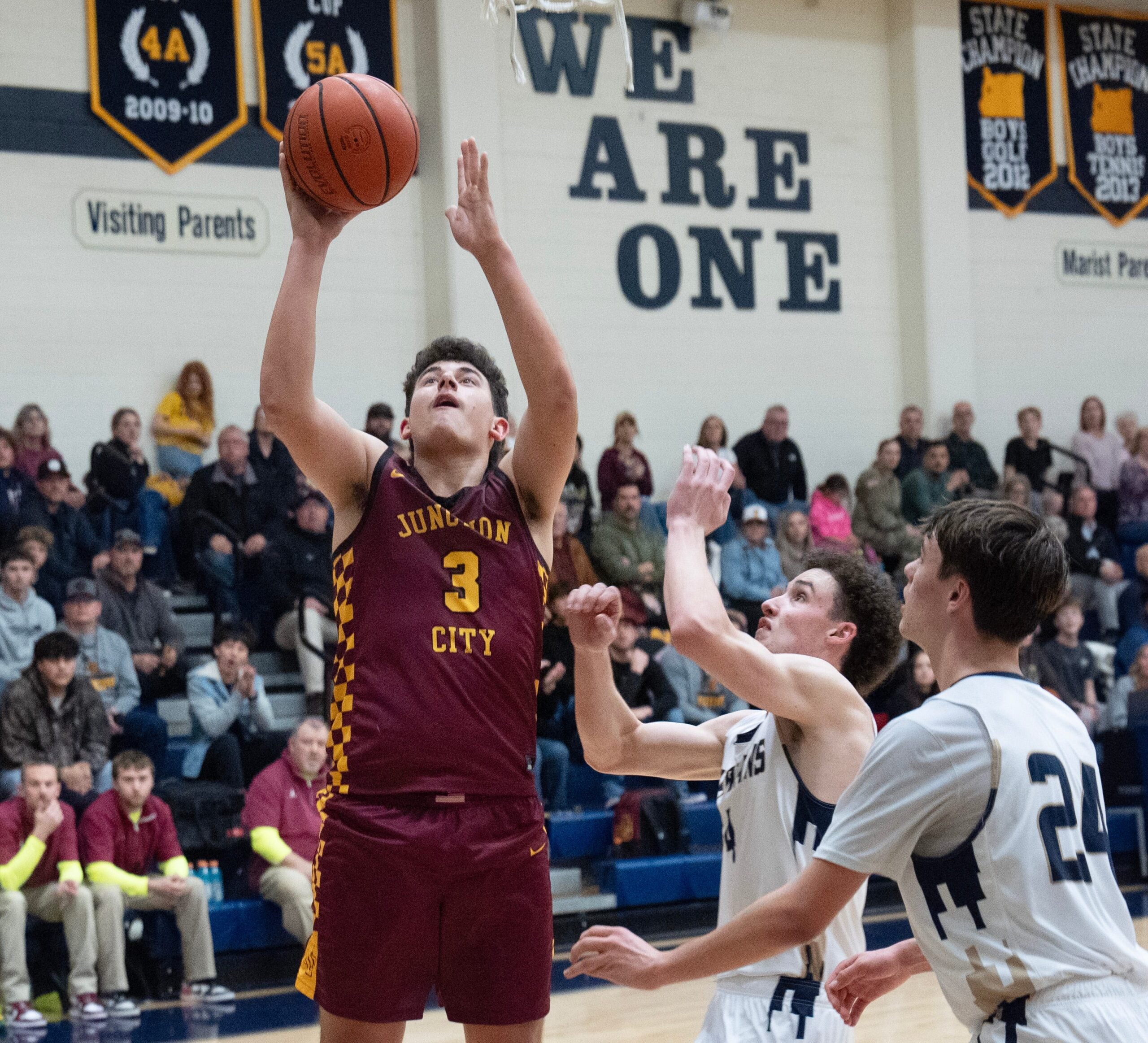 Boys basketball Junction City’s Kaden Shafer, left, shots ahead of Marist Catholic’s Gianni Lombardi and Fletcher Pollard, right, during the second half in Eugene Feb. 3, 2026.