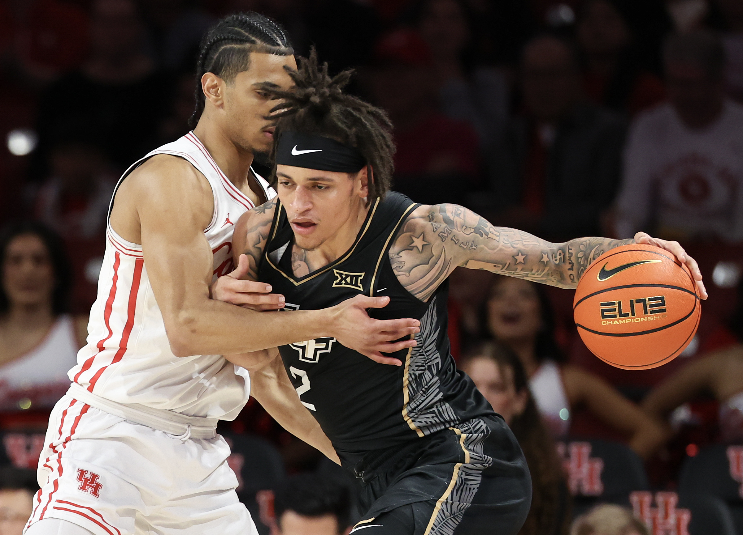Feb 4, 2026; Houston, Texas, USA;  UCF Knights guard Riley Kugel (2) drives against Houston Cougars guard Milos Uzan (7) in the first half at Fertitta Center. Mandatory Credit: Thomas Shea-Imagn Images