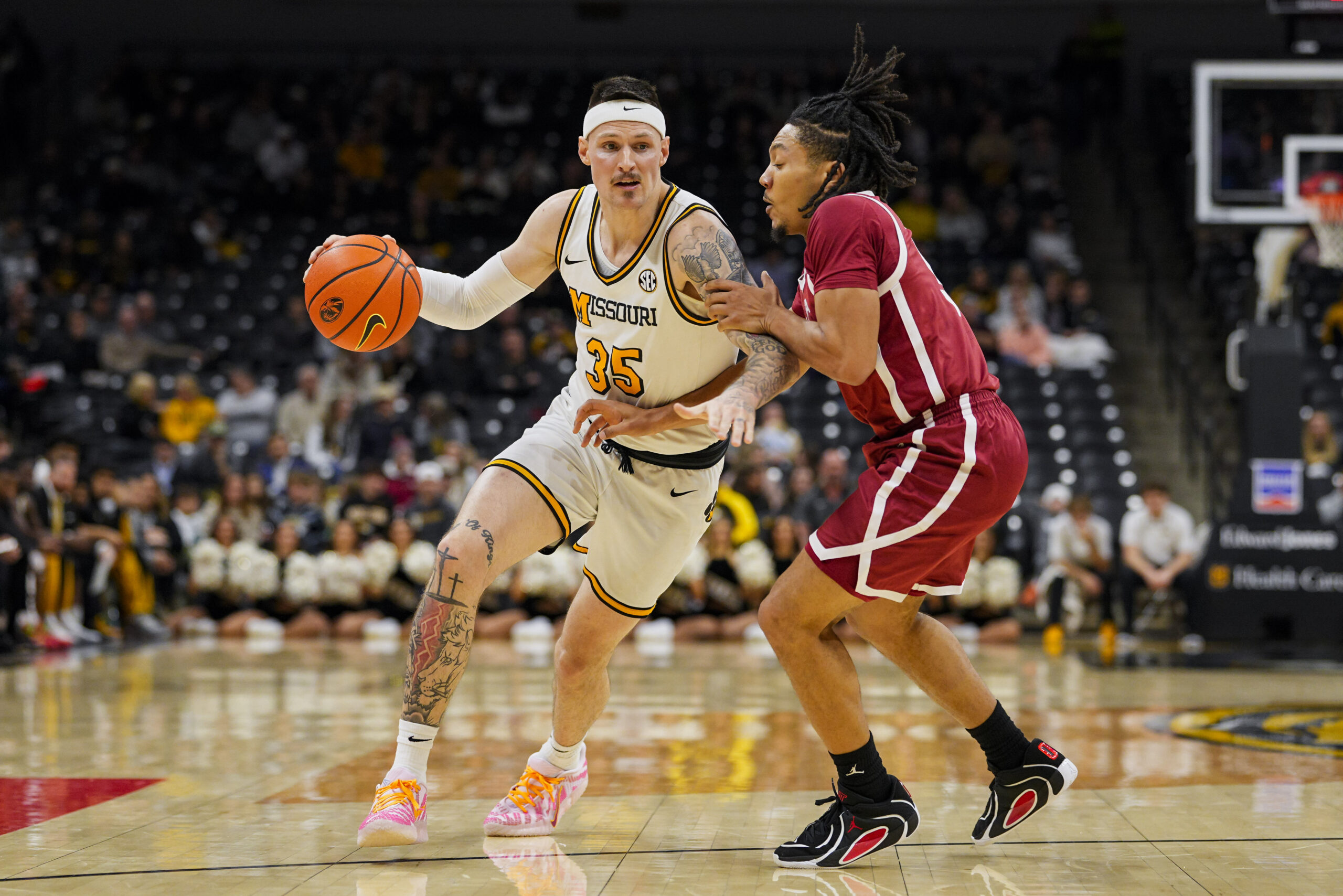 Jan 24, 2026; Columbia, Missouri, USA; Missouri Tigers guard Jacob Crews (35) drives against Oklahoma Sooners guard Nijel Pack (9) during the first half at Mizzou Arena. Mandatory Credit: Jay Biggerstaff-Imagn Images