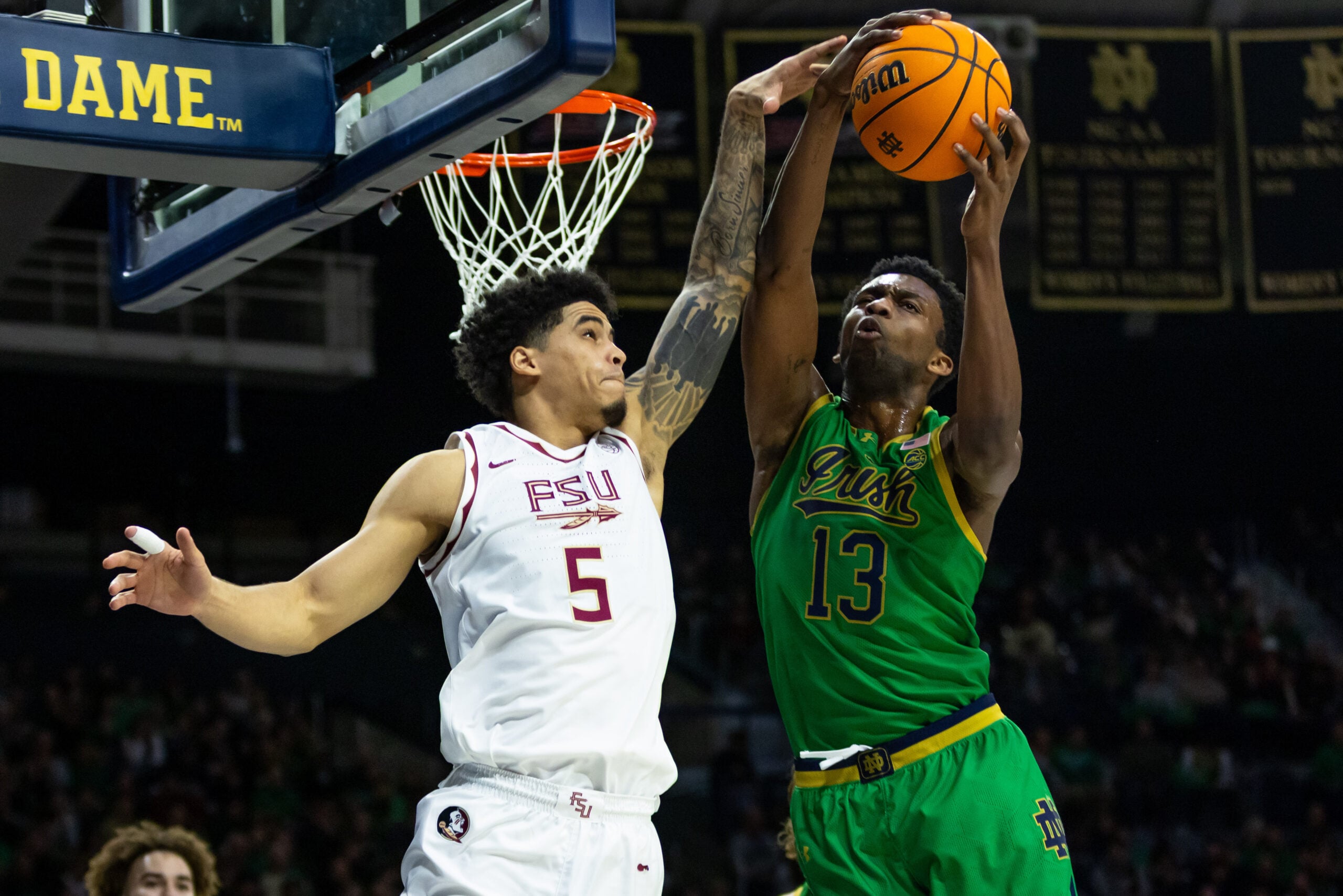 Feb 7, 2026; South Bend, Indiana, USA; Notre Dame Fighting Irish guard Sir Mohammed (13) and Florida State Seminoles guard Kobe Magee (5) fight for a rebound during the second half at Purcell Pavilion at the Joyce Center. Mandatory Credit: Michael Caterina-Imagn Images