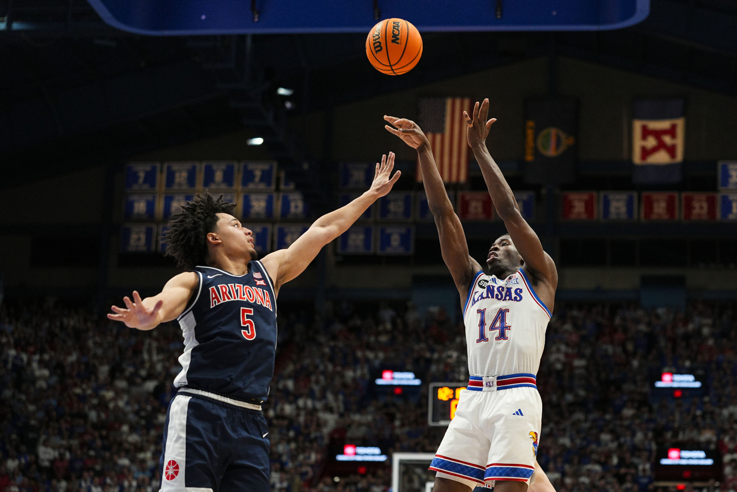 Feb 9, 2026; Lawrence, Kansas, USA; Kansas Jayhawks guard Melvin Council Jr. (14) shoots against Arizona Wildcats guard Brayden Burries (5) during the second half at Allen Fieldhouse. Mandatory Credit: Jay Biggerstaff-Imagn Images