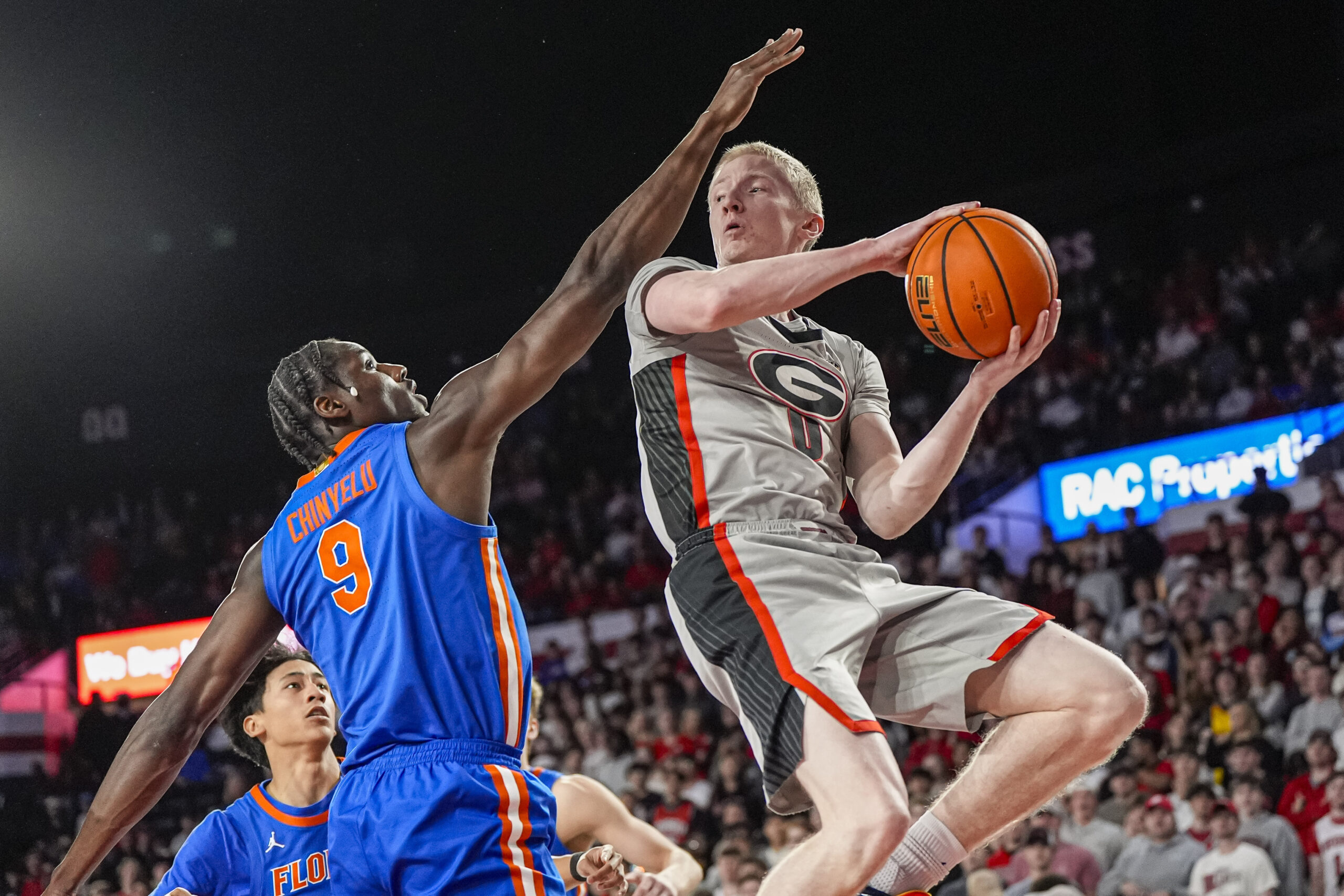 Feb 11, 2026; Athens, Georgia, USA; Georgia Bulldogs guard Blue Cain (0) looks to pass against Florida Gators center Rueben Chinyelu (9) during the first half at Stegeman Coliseum. Mandatory Credit: Dale Zanine-Imagn Images