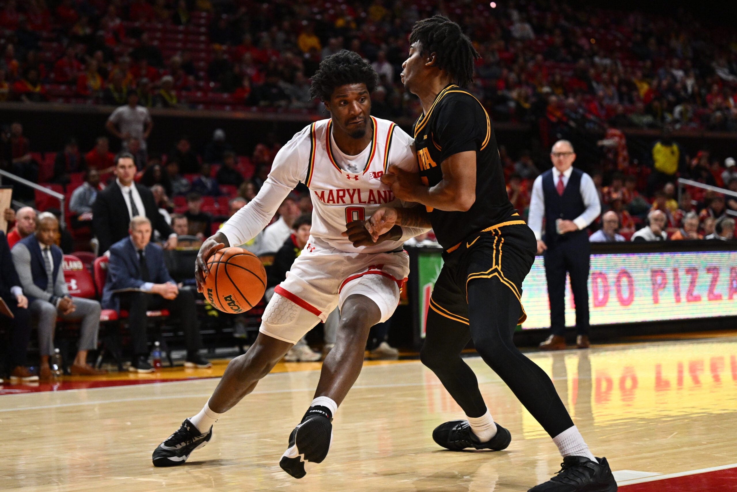 Feb 11, 2026; College Park, Maryland, USA; Maryland Terrapins forward Solomon Washington (9) drives to the basket as Iowa Hawkeyes guard Tavion Banks (#6) defends in the second half at Xfinity Center. Mandatory Credit: Jamie Sabau-Imagn Images
