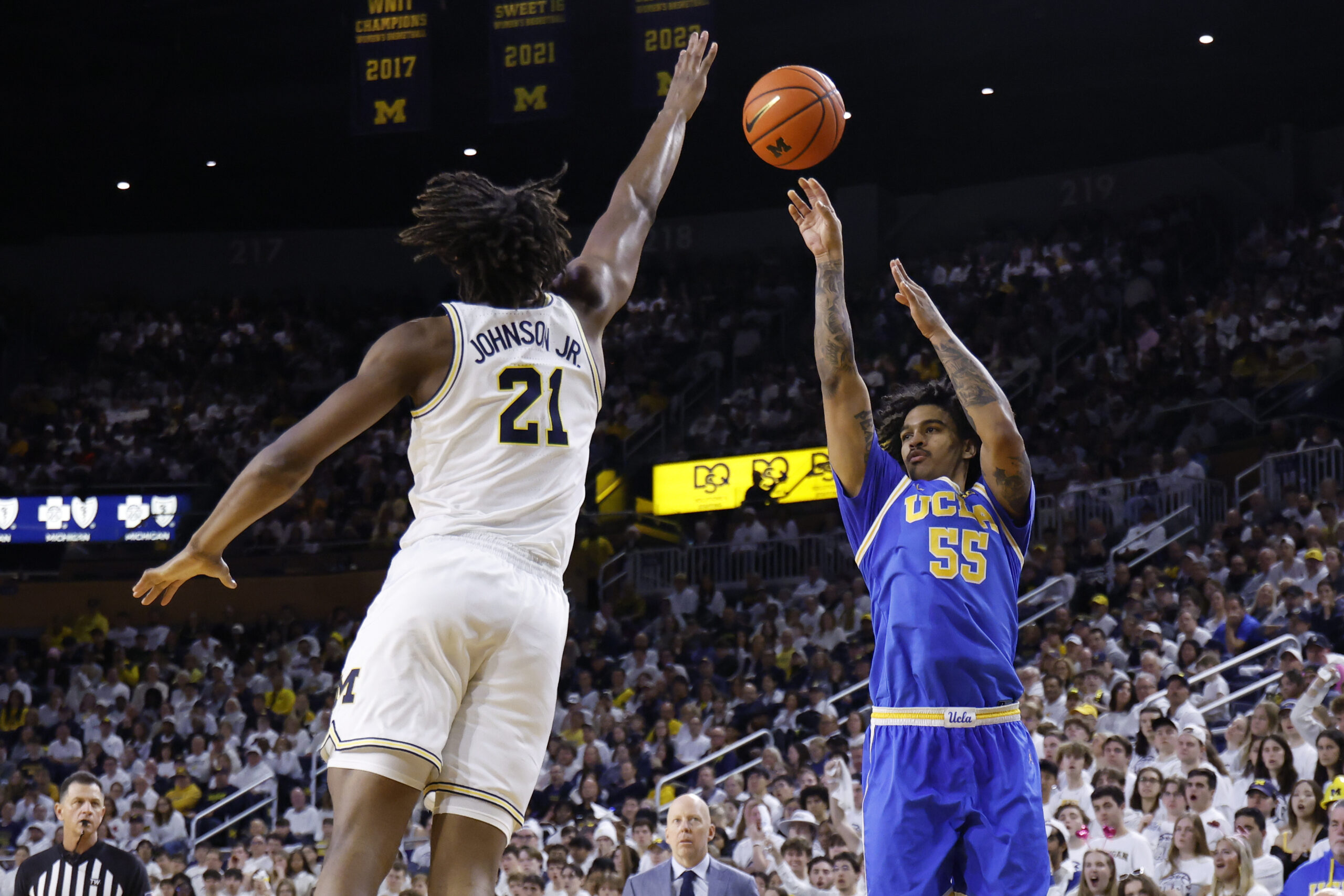 Feb 14, 2026; Ann Arbor, Michigan, USA; UCLA Bruins guard Skyy Clark (55) shoots on Michigan Wolverines forward Morez Johnson Jr. (21) in the second half at Crisler Center. Mandatory Credit: Rick Osentoski-Imagn Images