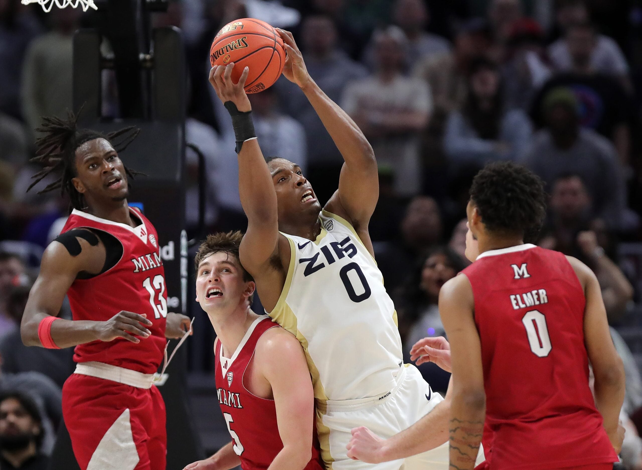 Akron Zips forward Amani Lyles grabs a rebound over Miami guard Peter Suder (5) during the Mid-American Conference Tournament championship game March 15, 2025, in Cleveland.
