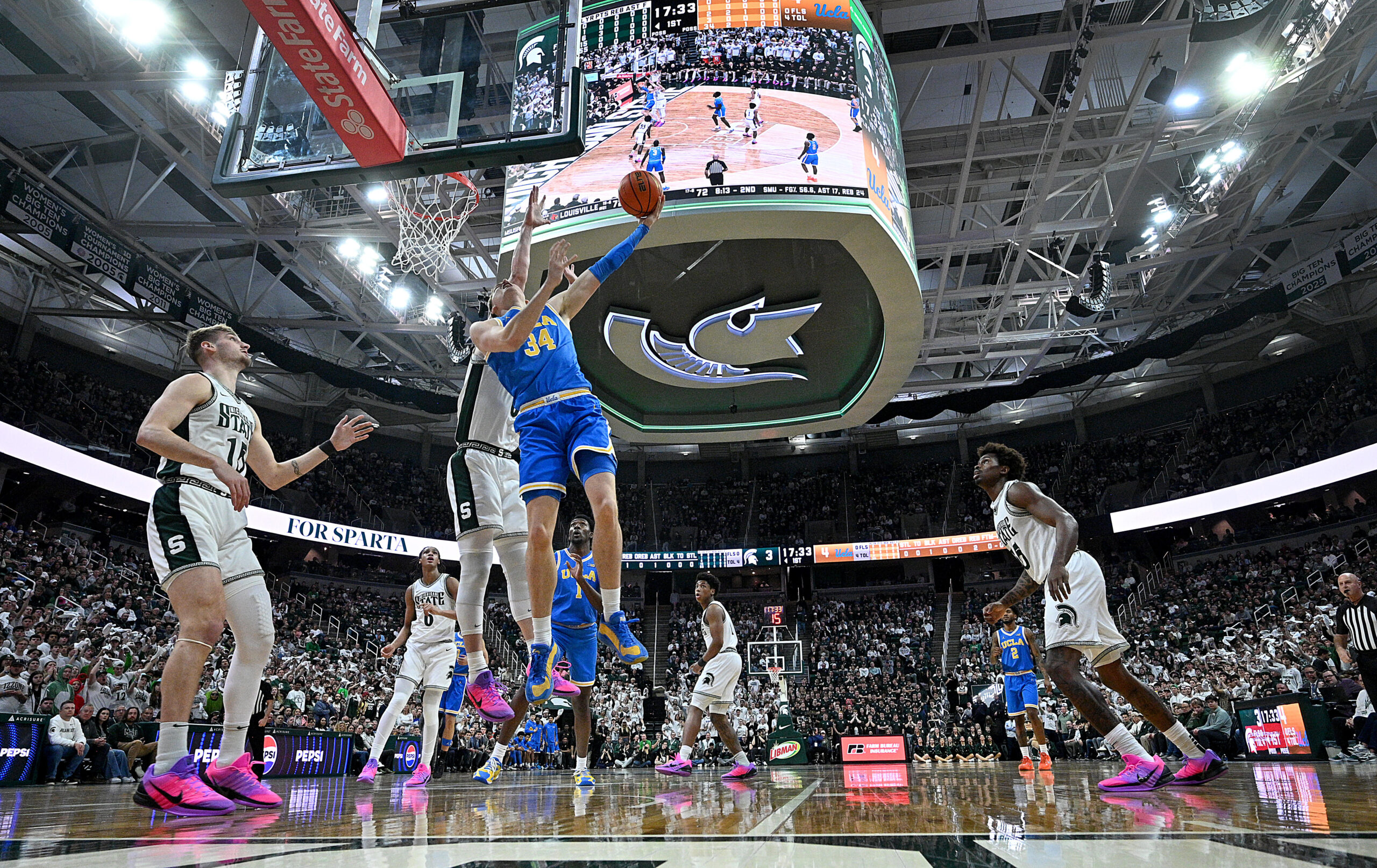 Feb 17, 2026; East Lansing, Michigan, USA; UCLA Bruins forward Tyler Bilodeau (34) tries a reverse shot off the glass during the first half against the Michigan State Spartans at Jack Breslin Student Events Center. Mandatory Credit: Dale Young-Imagn Images