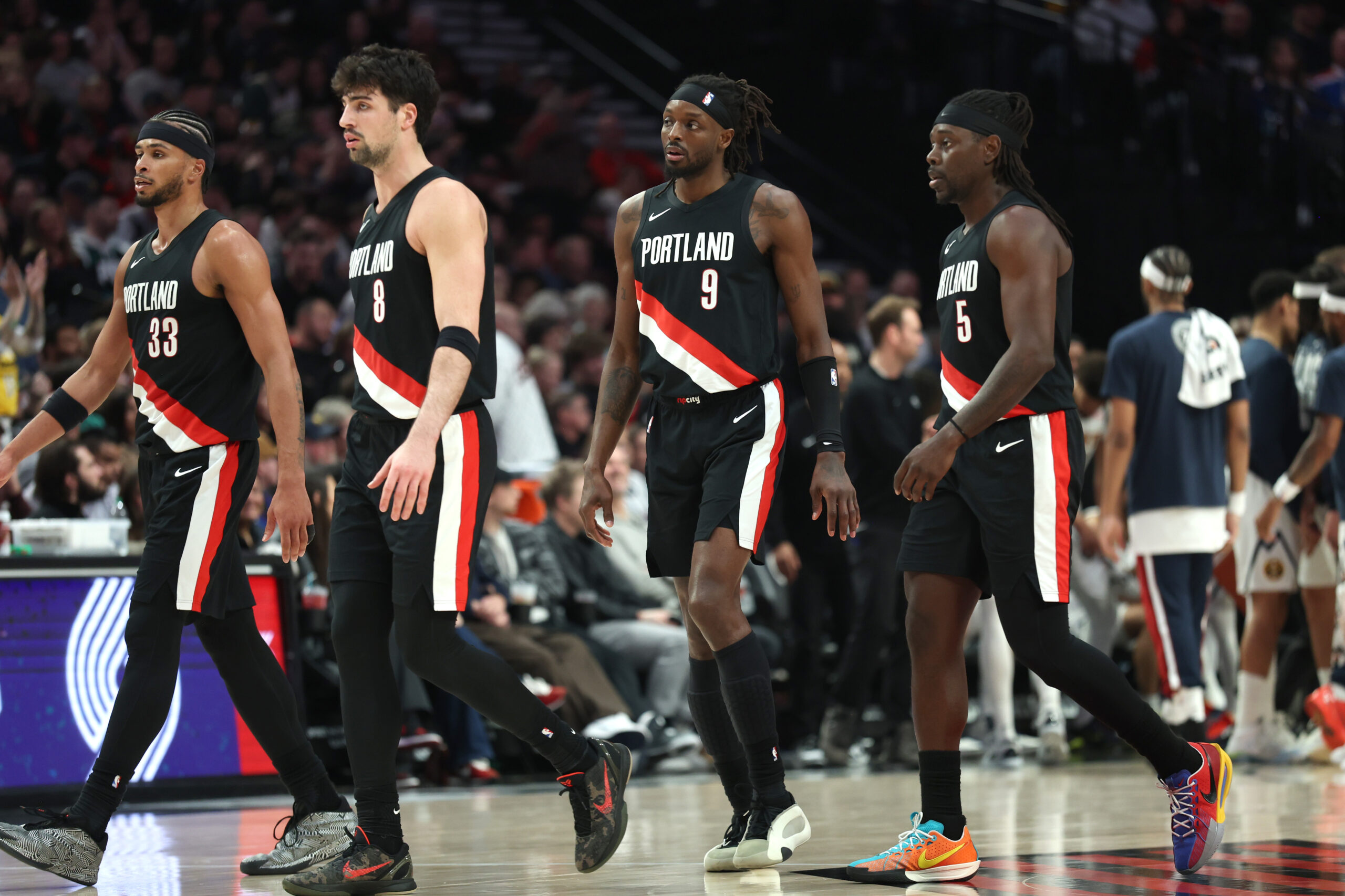 Feb 20, 2026; Portland, Oregon, USA; Portland Trail Blazers forward Toumani Camara (33), forward Deni Avdija (8), forward Jerami Grant (9) and guard Jrue Holiday (5) walk toward the bench in frustration during the second half against the Denver Nuggets at Moda Center. Mandatory Credit: Jaime Valdez-Imagn Images