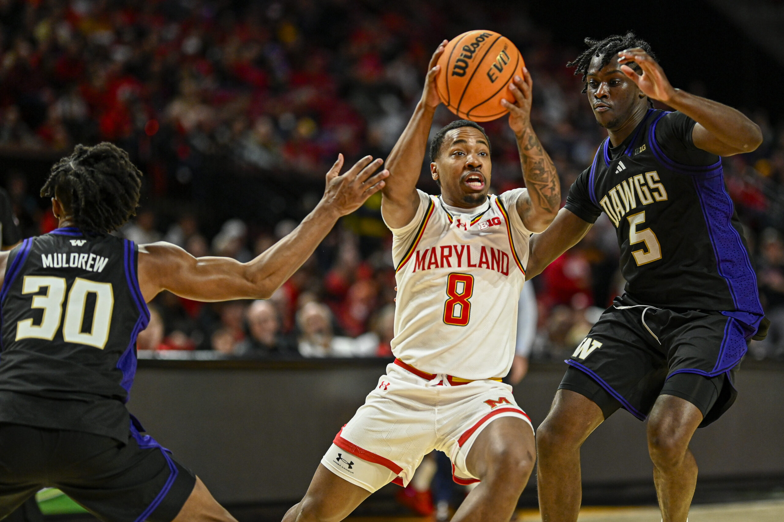 Feb 21, 2026; College Park, Maryland, USA; Maryland Terrapins guard David Coit (8) cuts between Washington Huskies guard Courtland Muldrew (30) and guard Zoom Diallo (5) during the second half at Xfinity Center. Mandatory Credit: Tommy Gilligan-Imagn Images