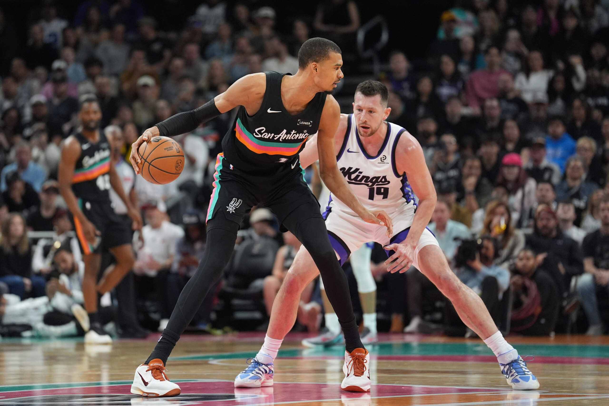 Feb 21, 2026; Austin, Texas, USA; San Antonio Spurs forward Victor Wembanyama (1) dribbles in front of Sacramento Kings forward Drew Eubanks (19) in the second half at Moody Center. Mandatory Credit: Daniel Dunn-Imagn Images